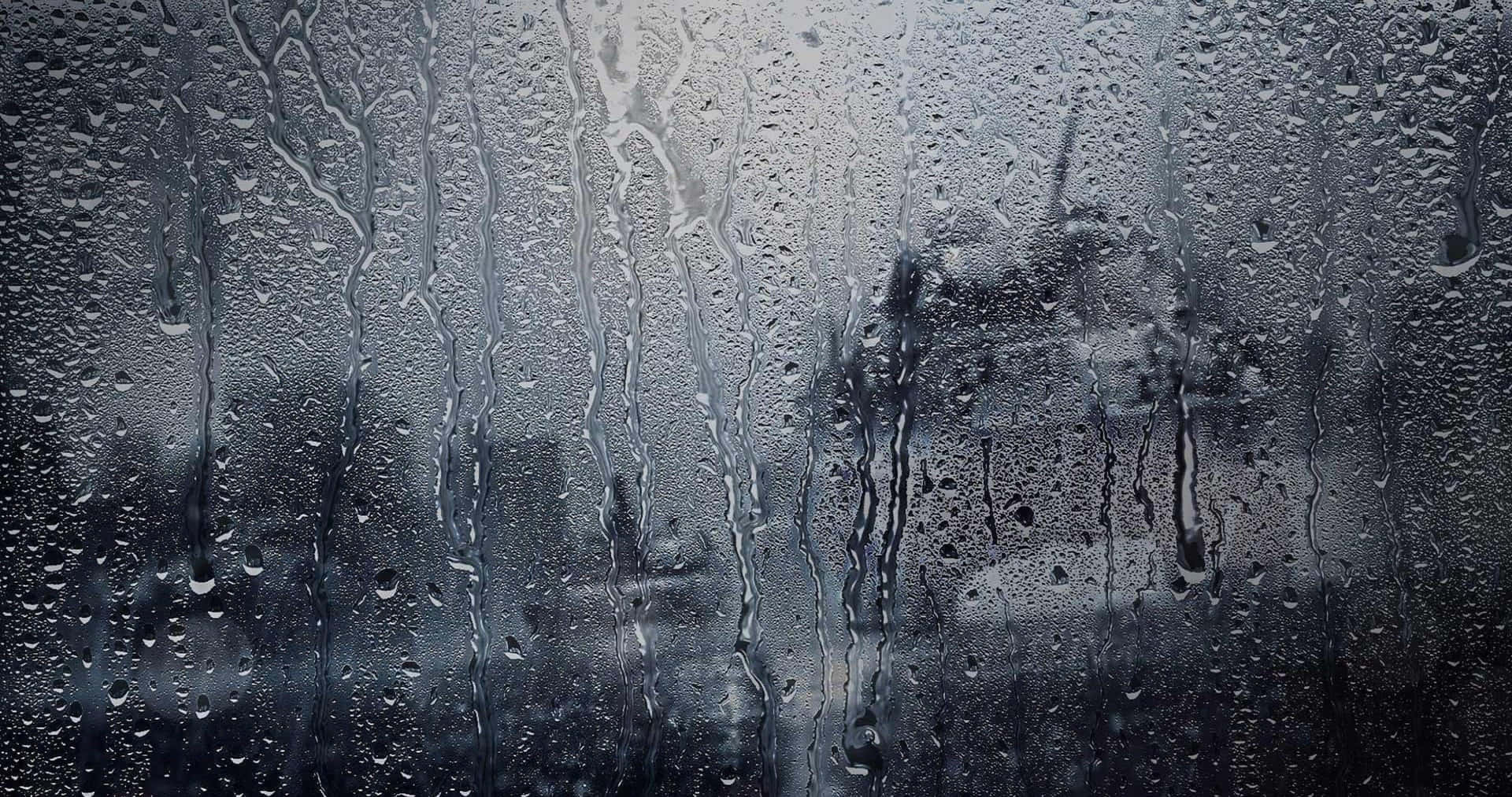 雨滴沿玻璃窗流下，模糊的城市景觀。