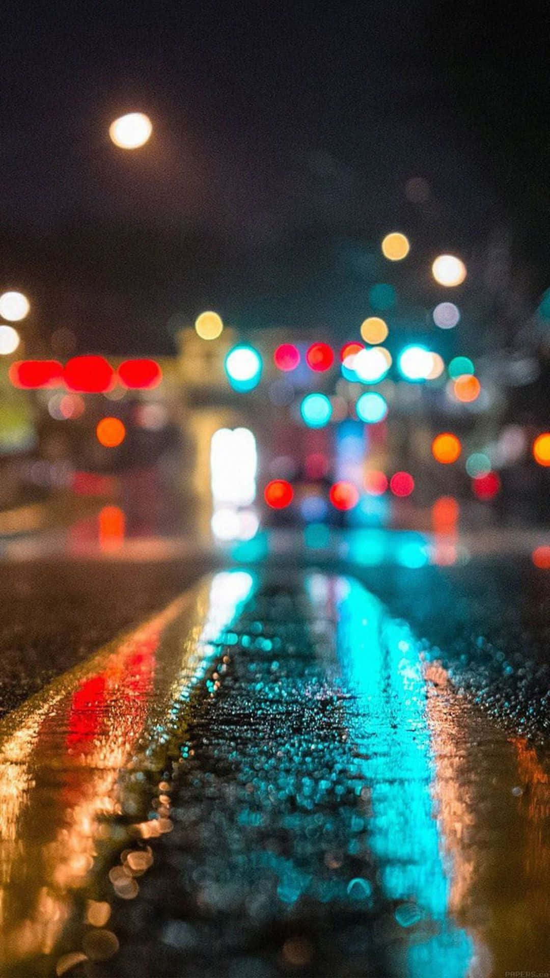 iPhone 8 Plus 桌布 壁紙 — 雨濕的夜間城市街道，濕漉漉的瀝青上反射著發光的散景燈光。