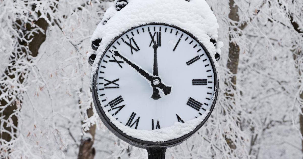 冬季森林中帶有羅馬數字的雪覆蓋時鐘