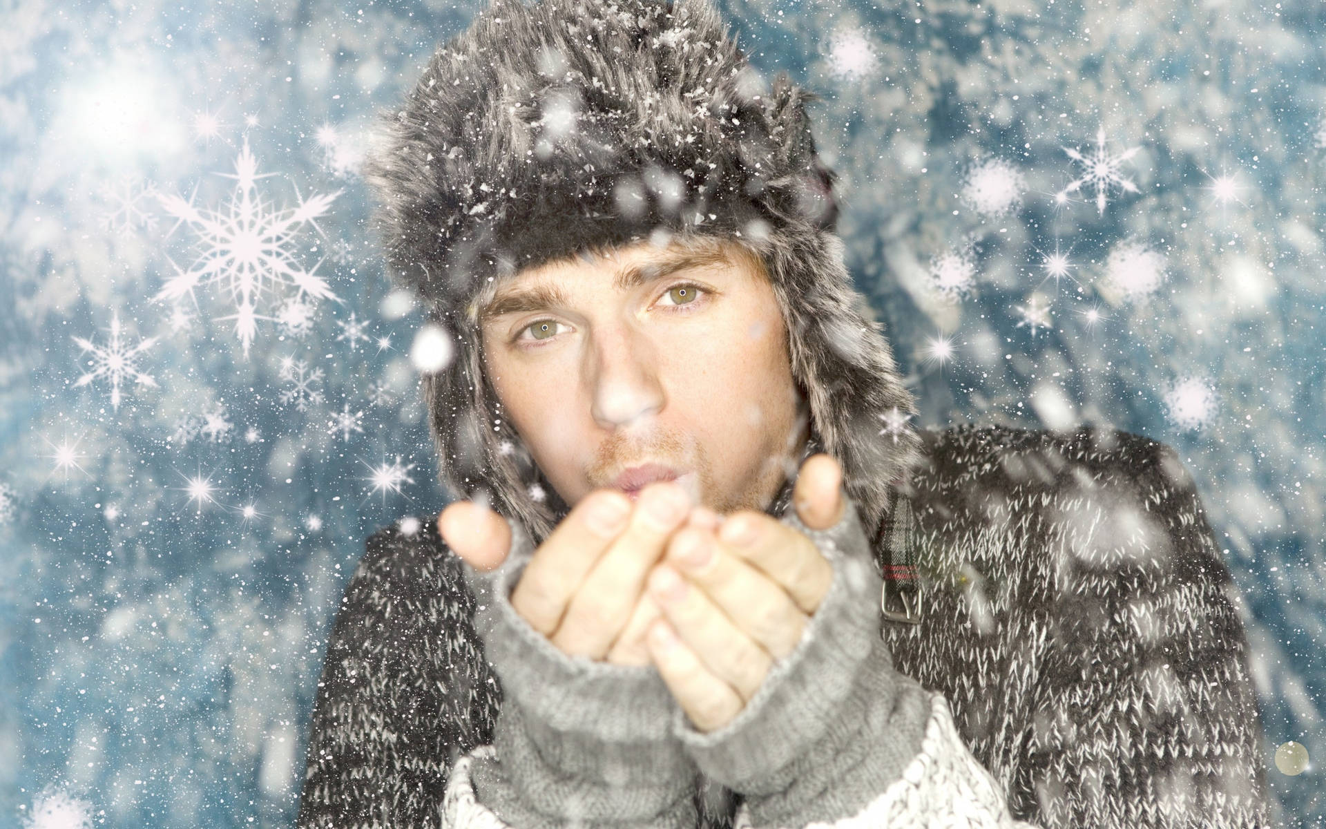 戴冬帽的年輕男子在雪景中吹雪花