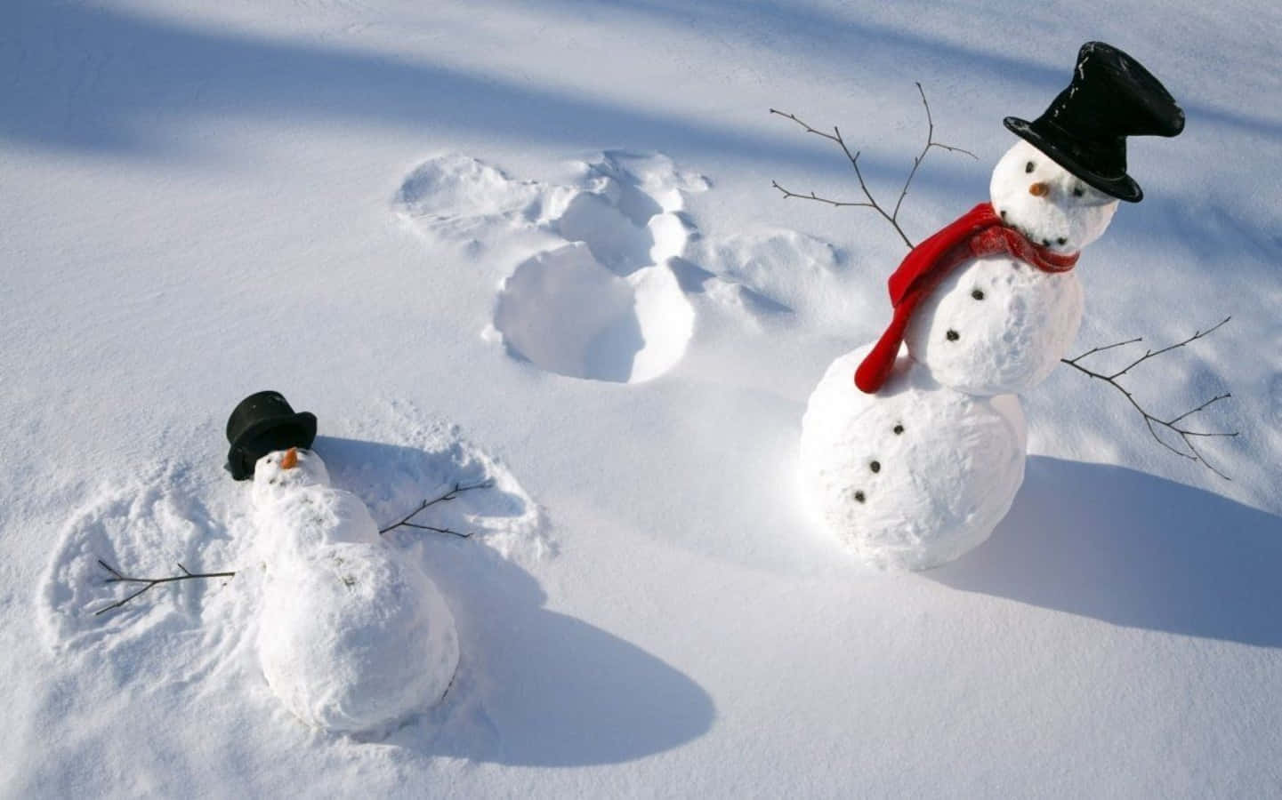 兩個雪人，一個站立，一個躺在深雪中，在明亮陽光下。