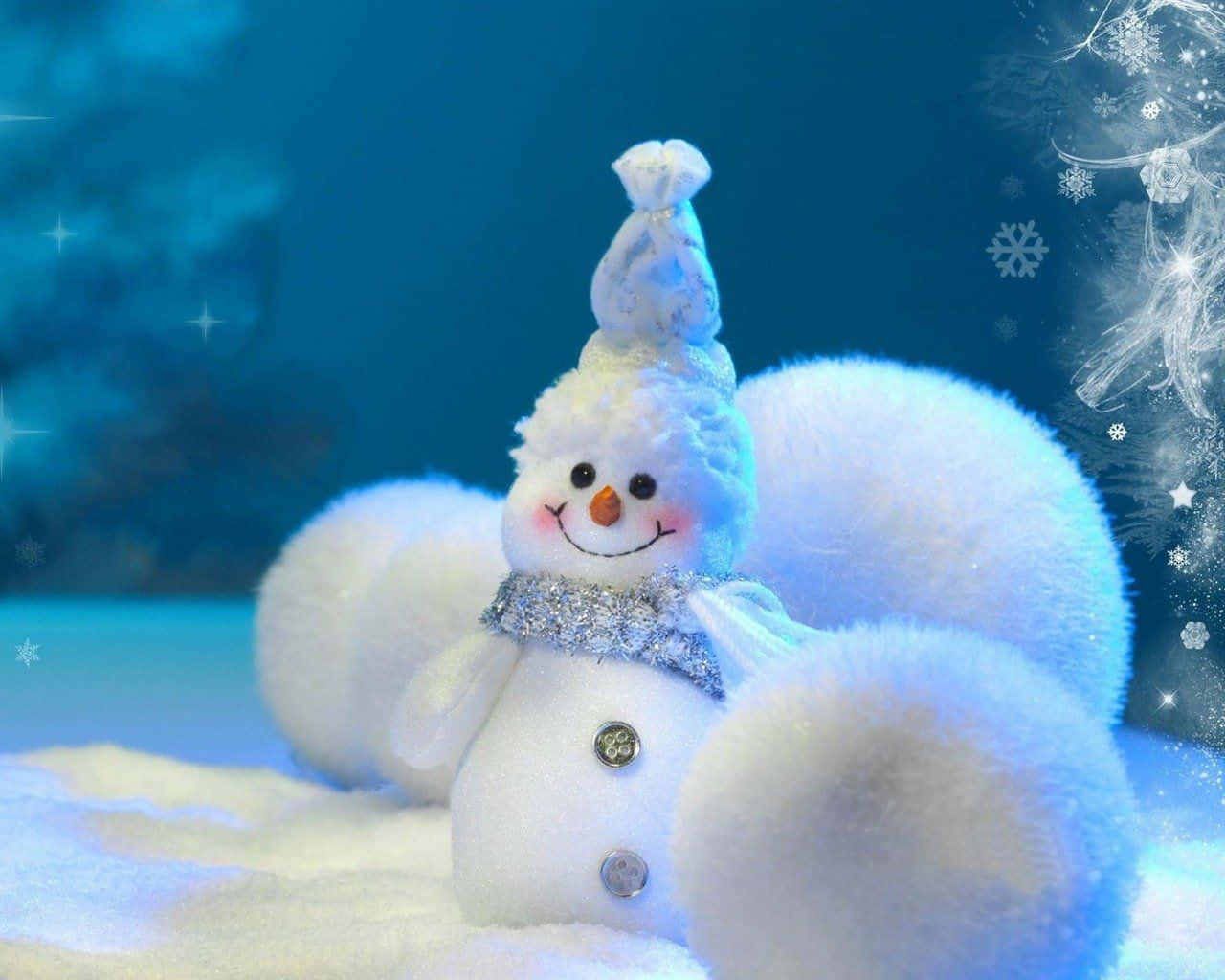 雪人聖誕美學電腦壁紙 壁紙 — 一個毛茸茸的雪人，戴著閃閃發光的圍巾和小帽子，坐在雪藍色的光線中，閃爍的雪花在周圍旋轉。