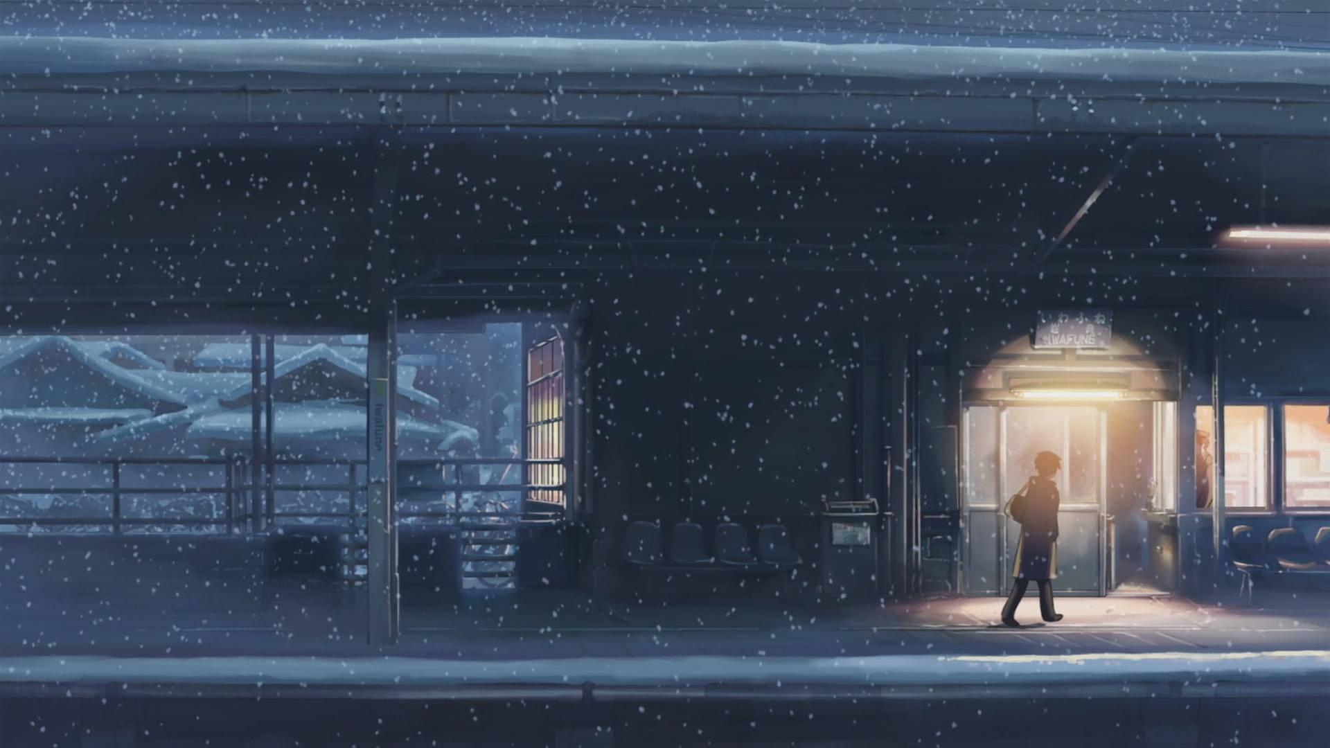 一個人在夜晚的雪中走過被雪覆蓋的火車站。