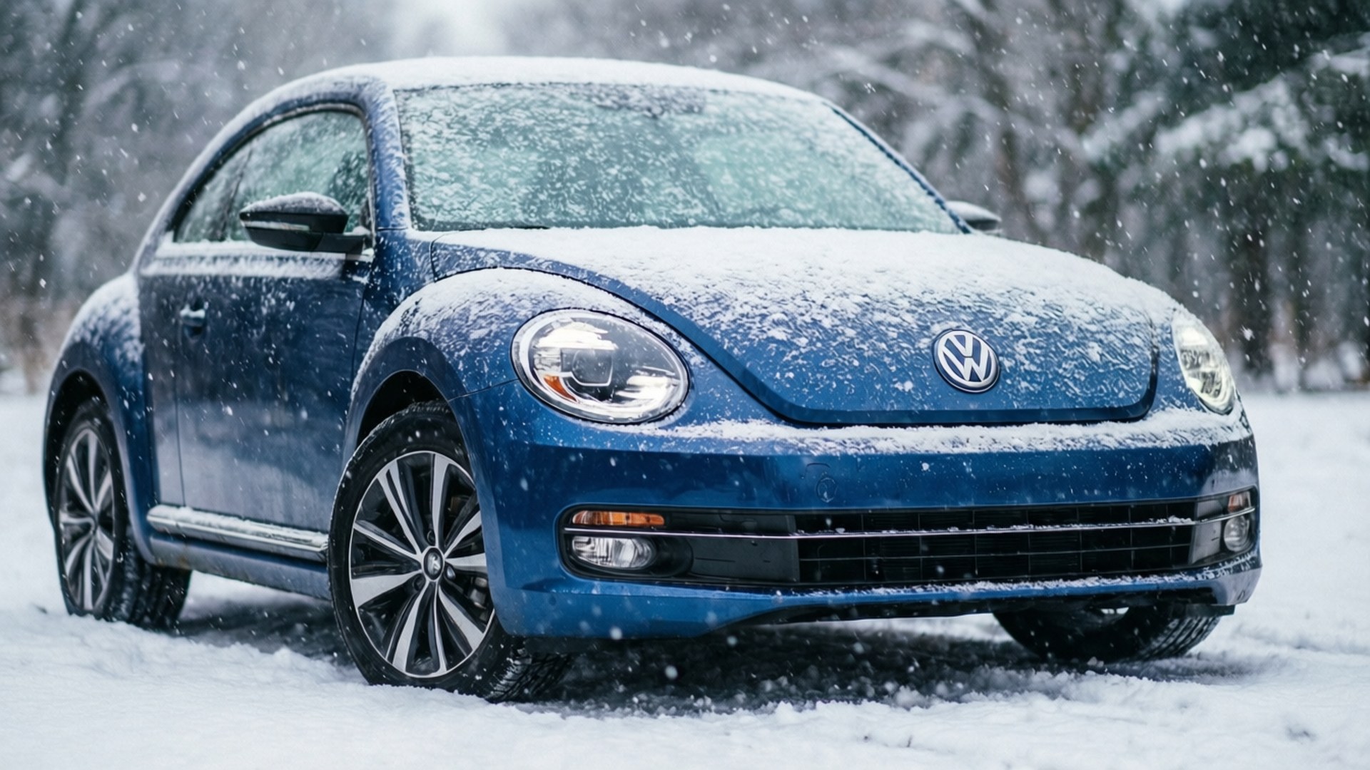 一輛藍色福士甲蟲車停在雪中，周圍有雪飄落的森林