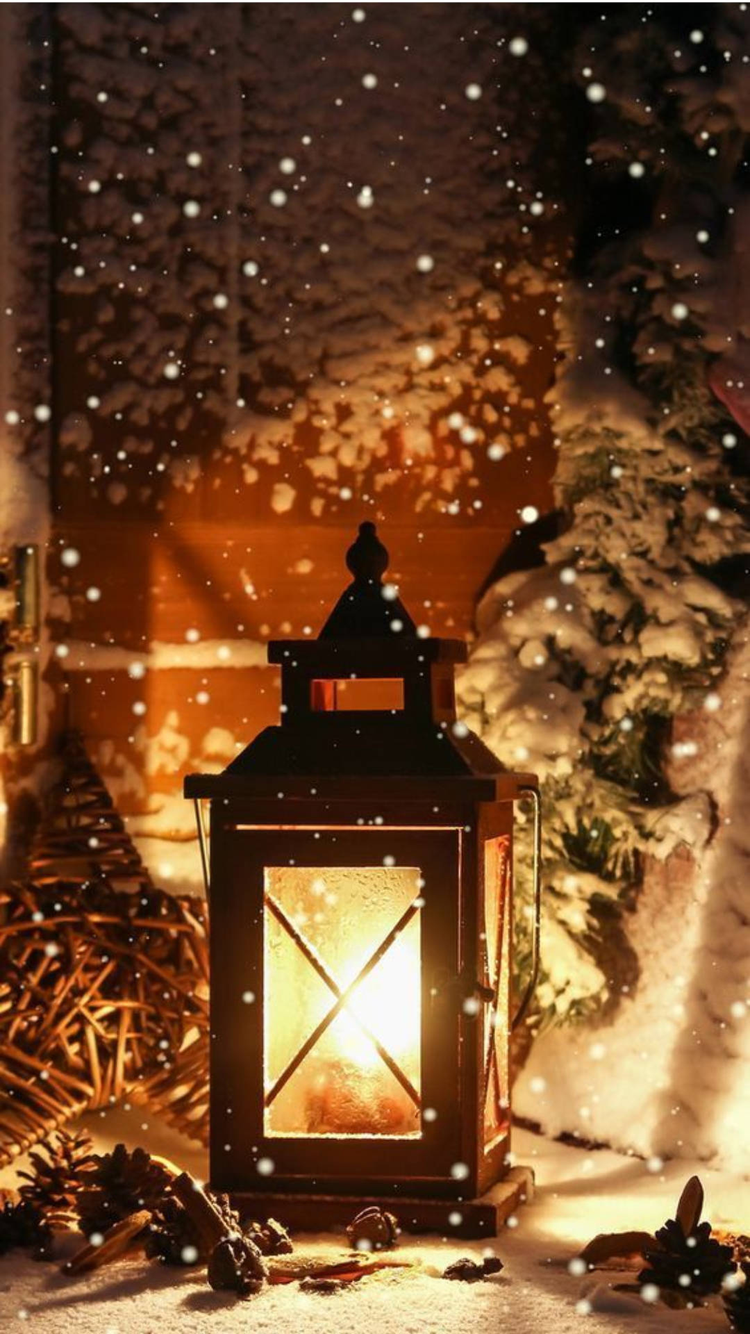 雪夜戶外燈光壁紙 壁紙 — 一盞發光的燈籠在夜晚飄落的雪花中，將溫暖的光芒投射在積雪的松樹枝和松果上。