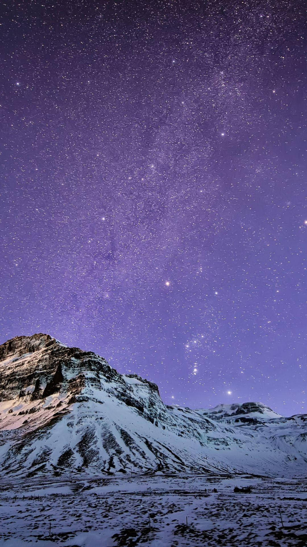 雪山 iPhone 6s Plus 壁紙 — 白雪覆蓋的山峰在充滿無數閃爍星星的鮮豔紫色夜空下升起。