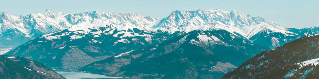 晴朗天空下，山谷中有湖泊的雪山山脈。
