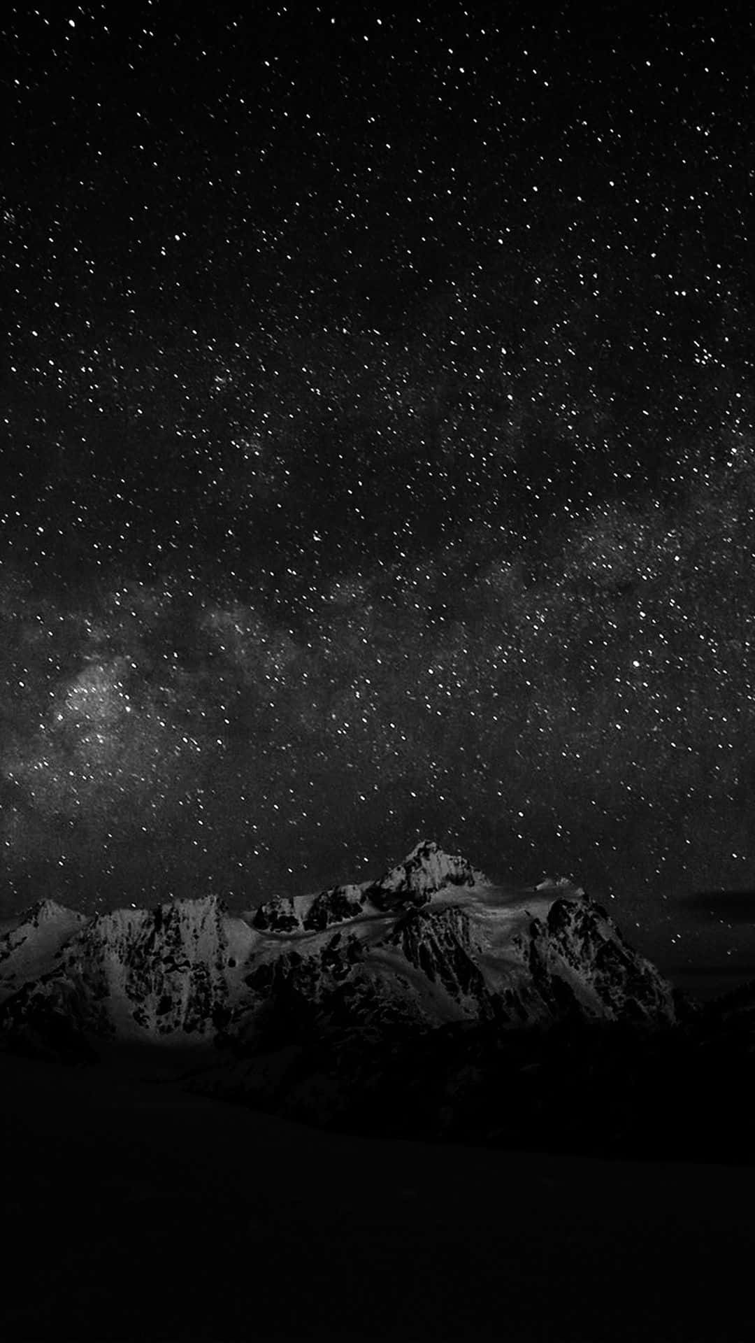 雪山與繁星交織的黑白夜景 壁紙 — 密集星野下，銀河拱橋般的雪頂山脈黑白景觀。