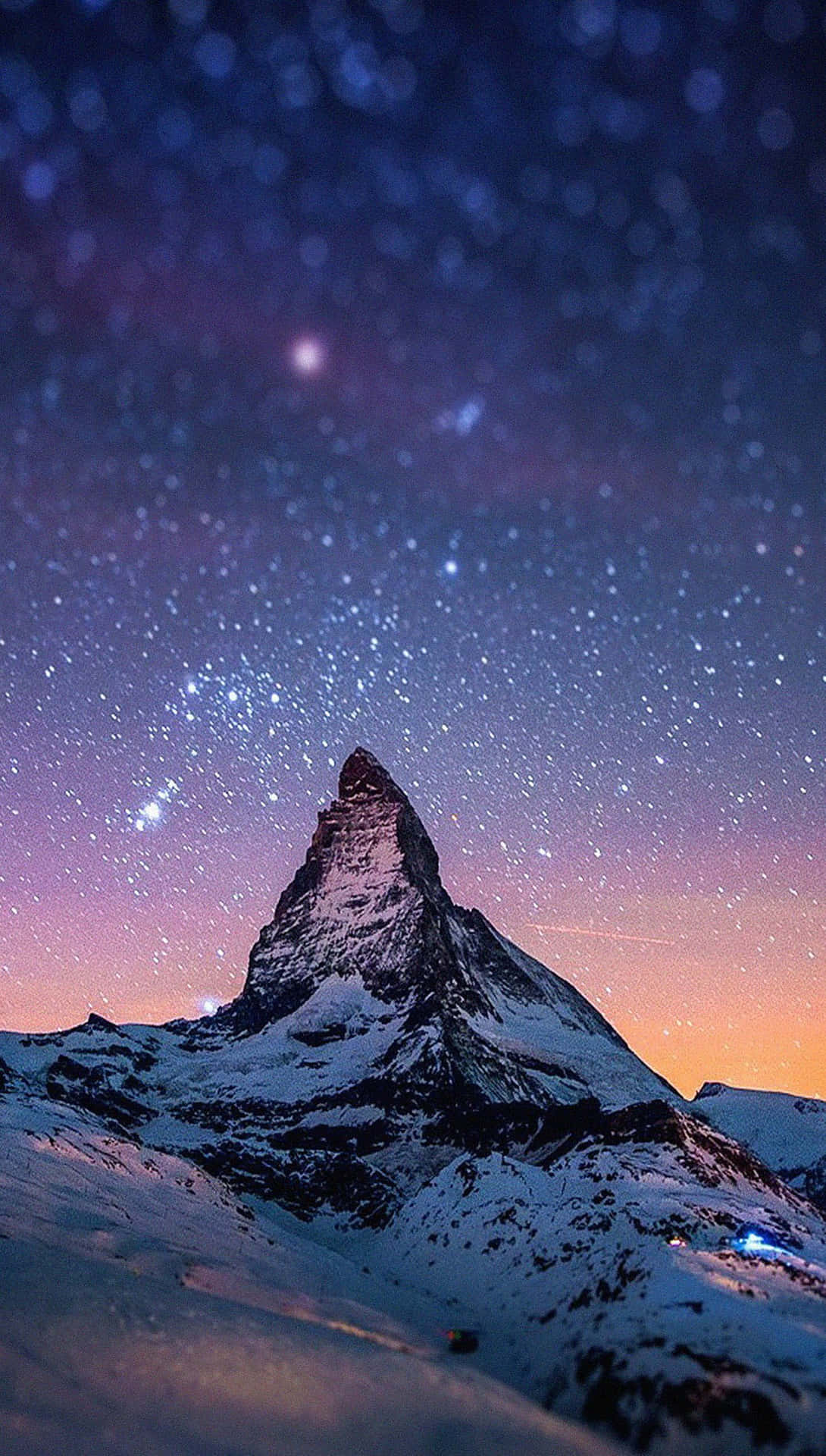 白雪覆蓋的馬特洪峰在星空暮色天空下，帶有紫色和橙色色調。