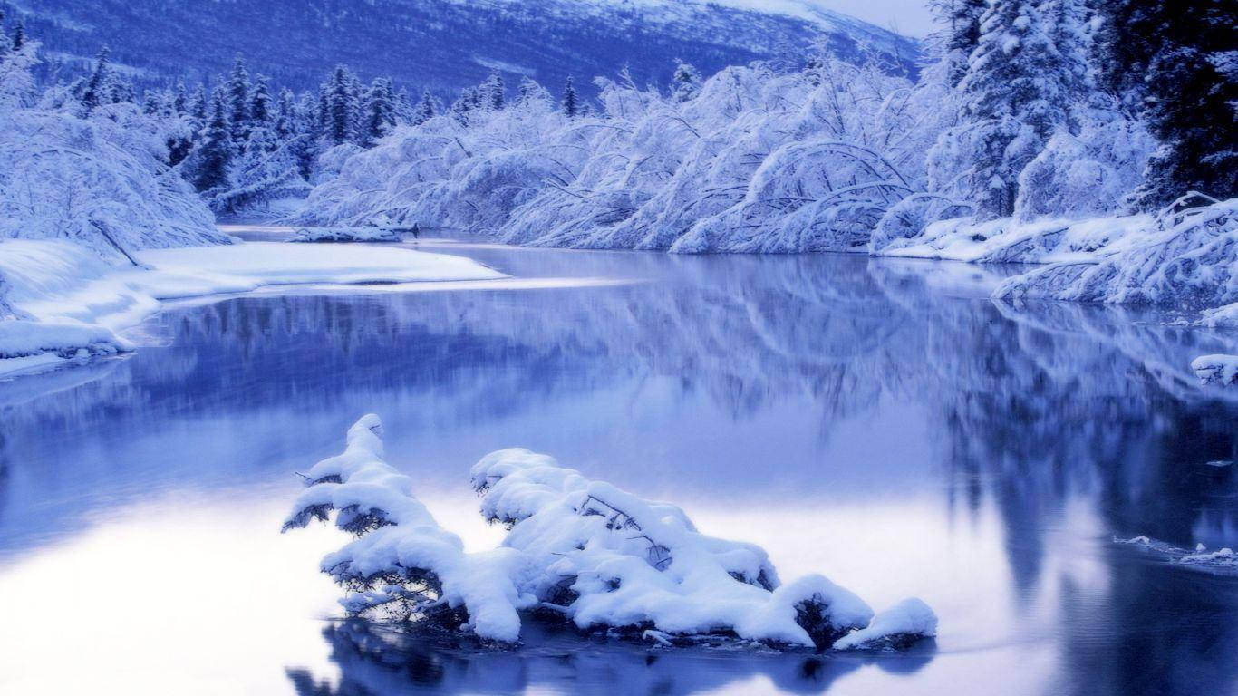 積雪河流，以冷藍色調反射冬日樹木和山脈。