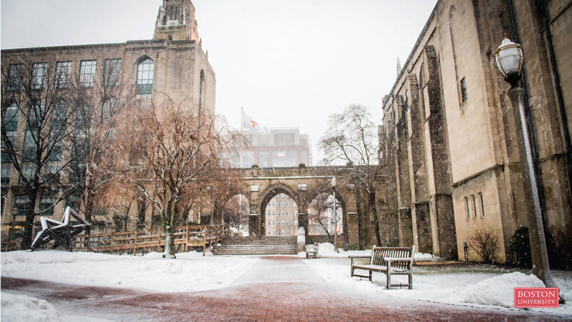白雪覆蓋的大學庭院，有石建築和磚砌步道。