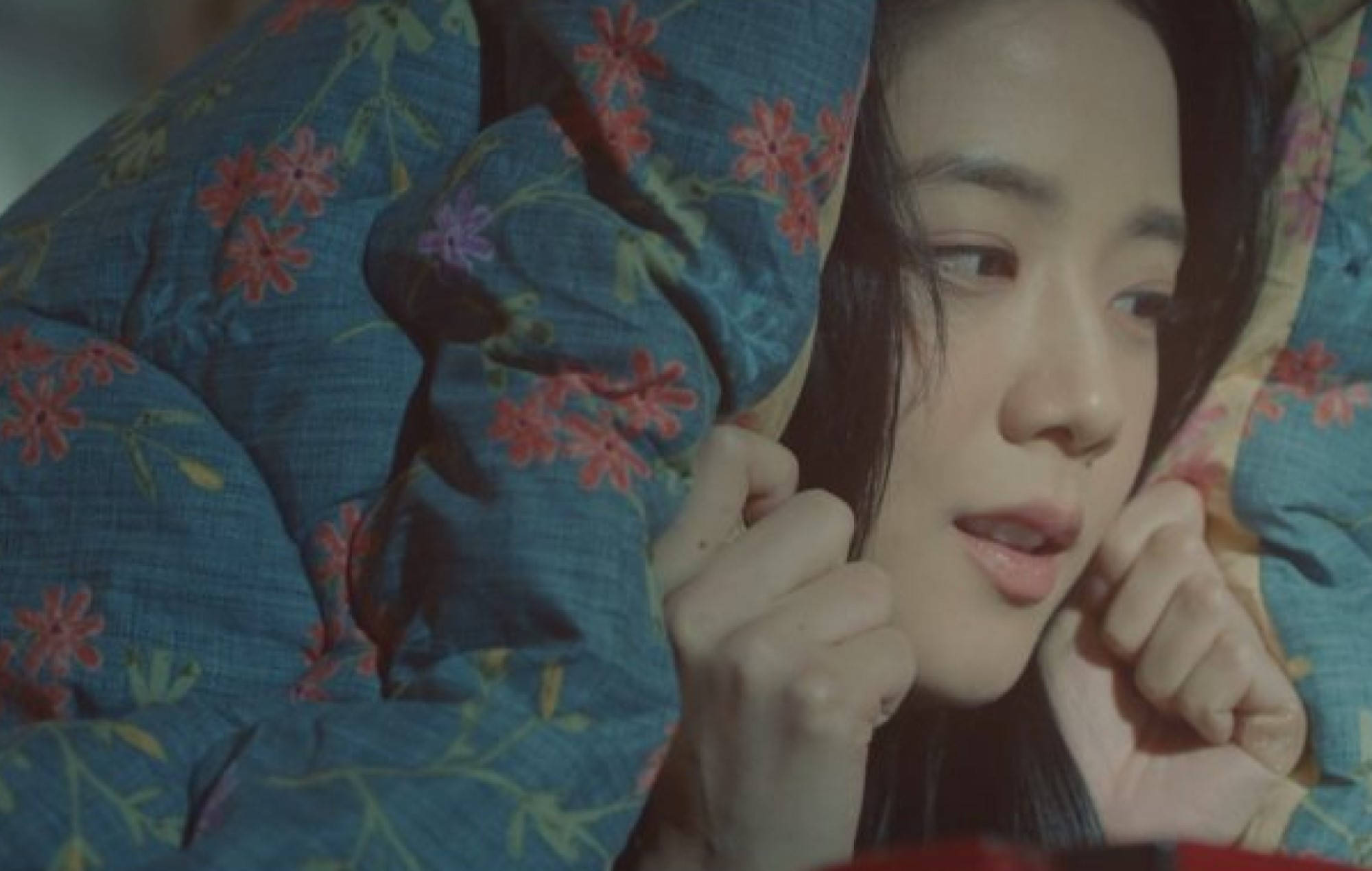 《雪滴花》劇中Eun Yeong-ro藏在毯子裡 壁紙 — 一位深色頭髮的年輕女子從藍色花卉被褥下探出頭來，雙手抓著靠近臉部的布料。