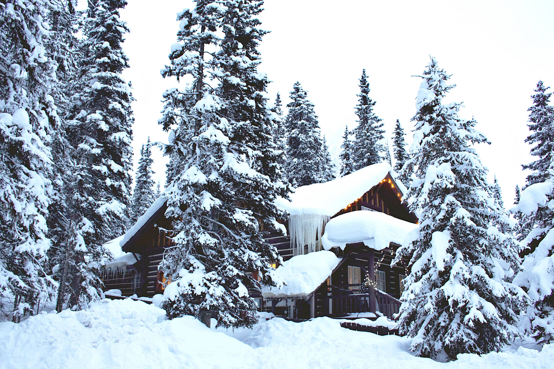 雪地森林中的舒適小屋，冰柱和溫暖的燈光從窗戶透出。