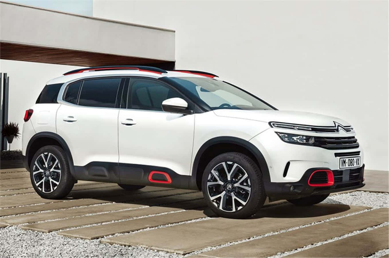 雪鐵龍C5 Aircross SUV — 升級您的駕駛體驗 壁紙 — 一輛時尚的白色雪鐵龍SUV帶有紅色點綴，停在石板地上，背景是現代簡約建築。