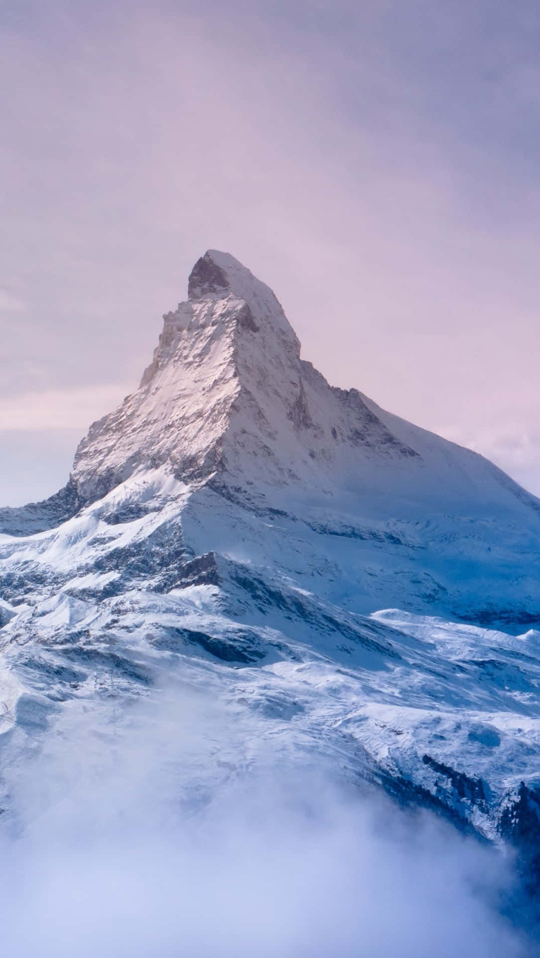 黎明時分，白雪覆蓋的馬特洪峰山頂聳立在雲層之上。