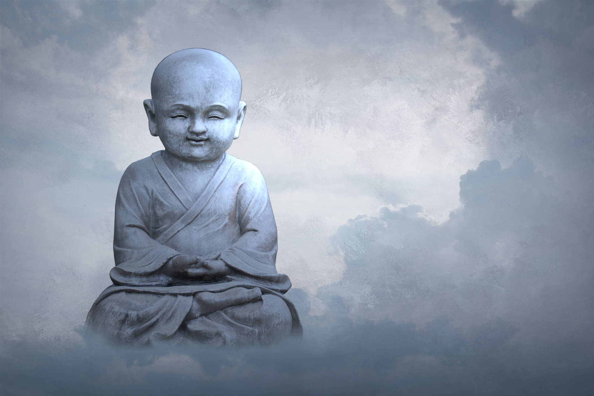 一個微笑的兒童僧侶在霧雲中打坐的石像。