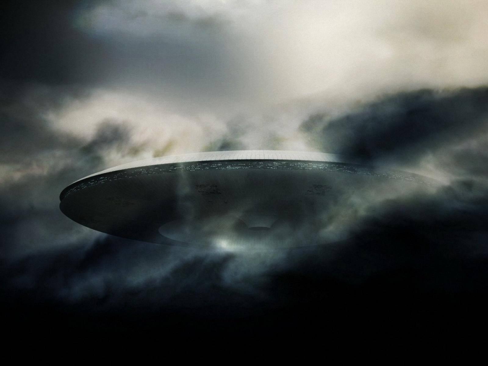 夜間，發光的UFO從黑暗的暴風雲中出現。