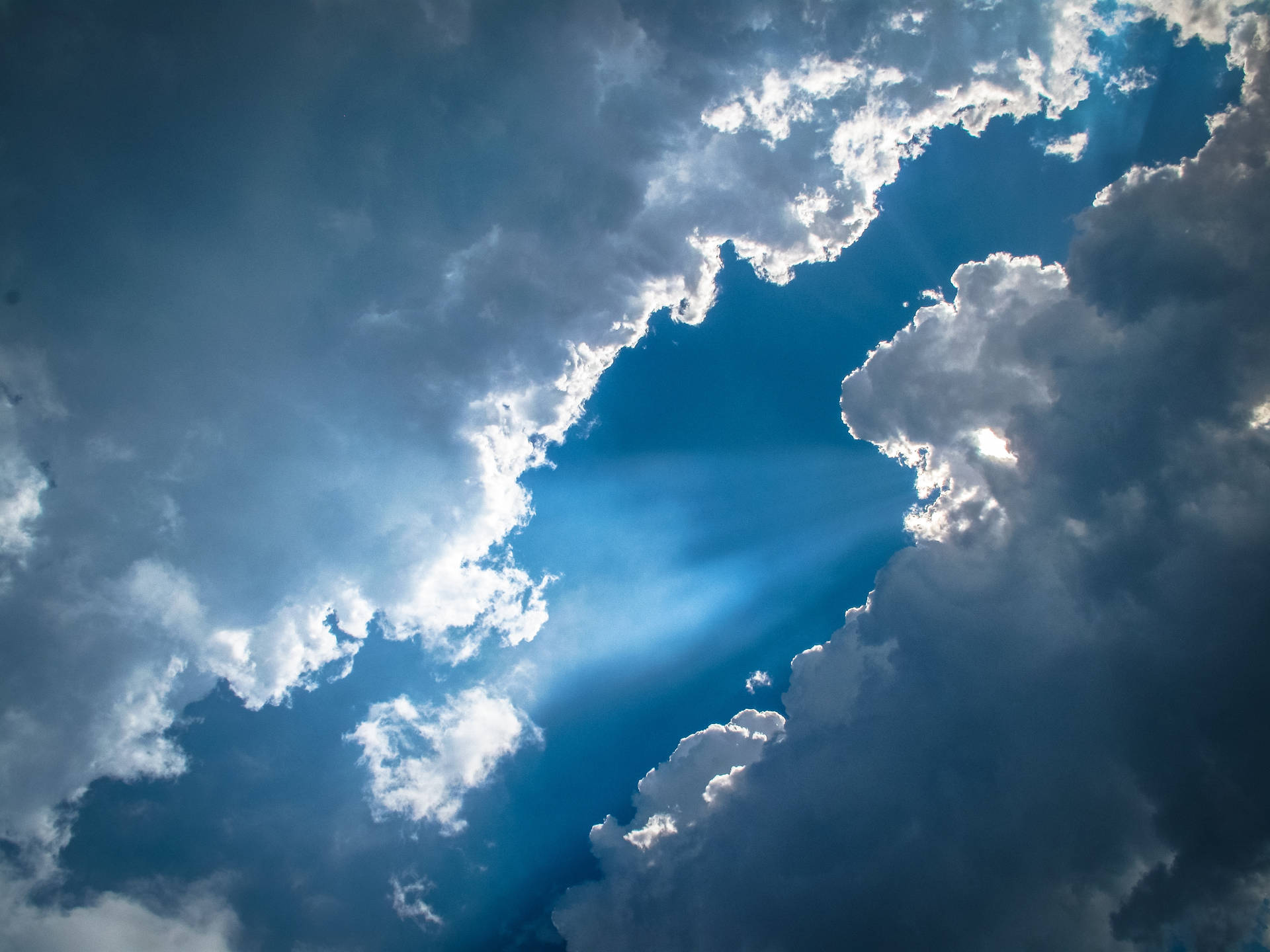 陽光穿過烏雲，在充滿活力的藍天中。