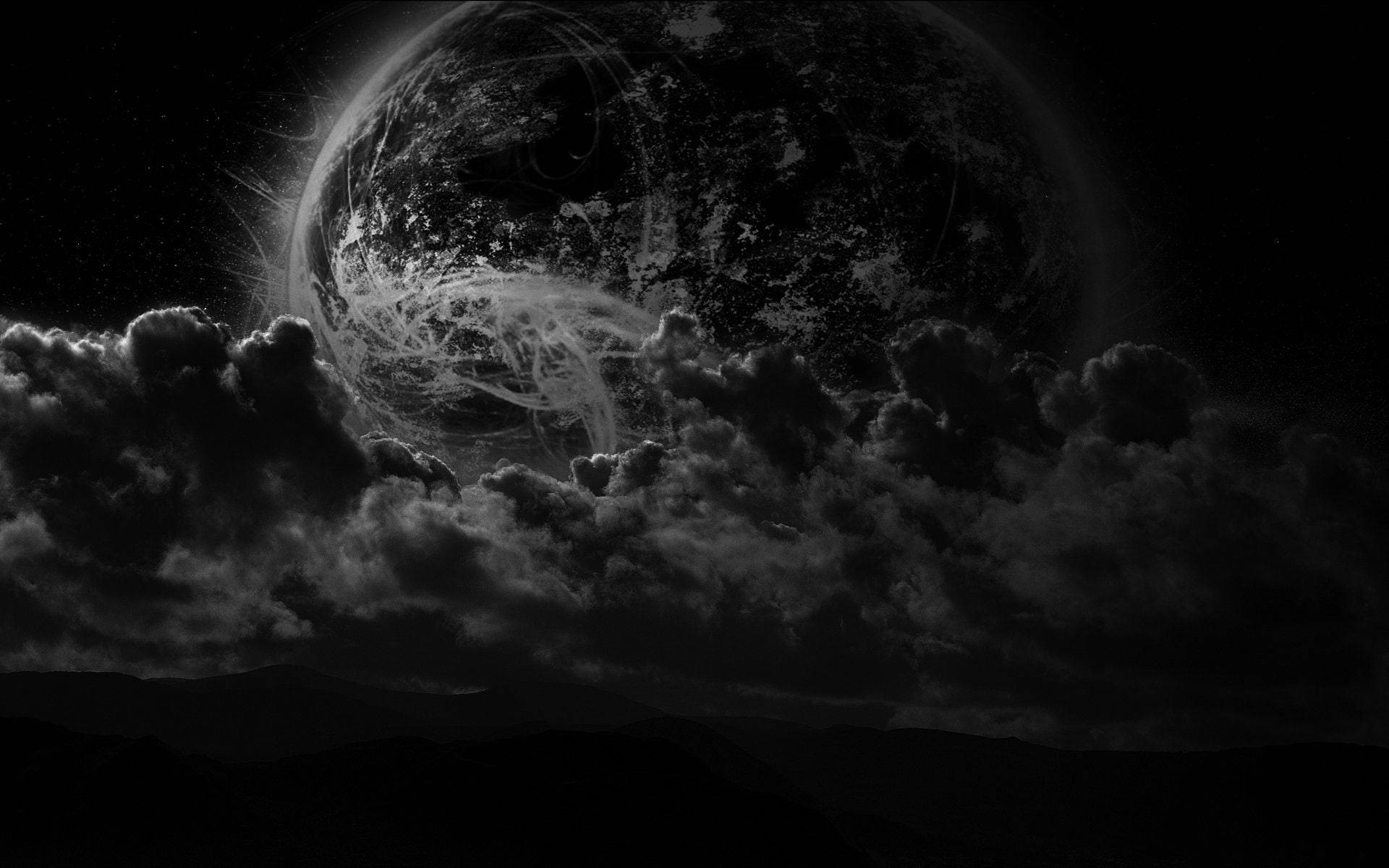 雲層之上的黑色星球地球 壁紙 — 在星空下，山脈上方的風暴雲後，一個單色行星隱現。