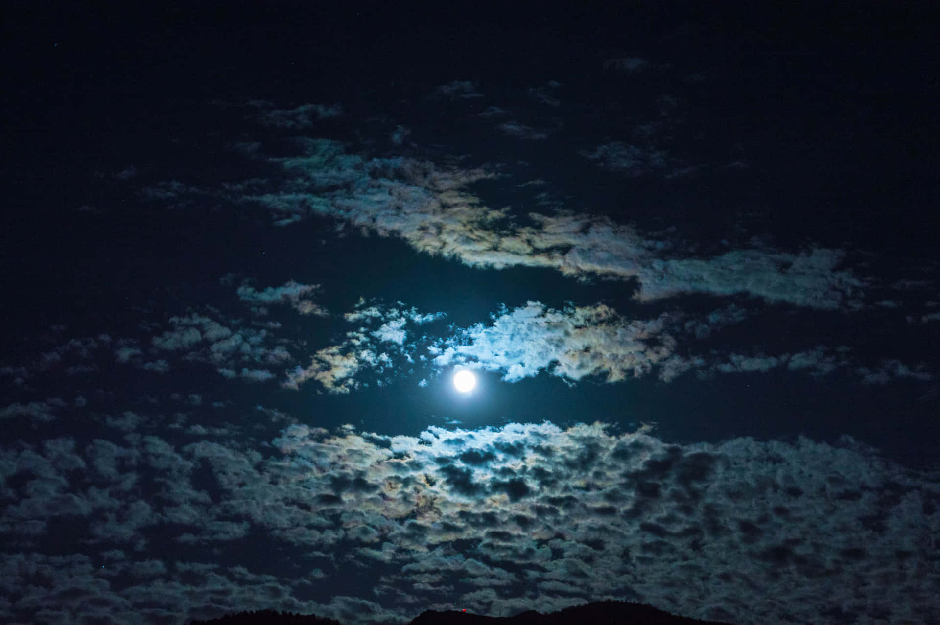 雲層夜月圖 壁紙 — 一輪明亮的滿月透過縷縷薄雲照耀在深邃的夜空，可見微弱的星星。