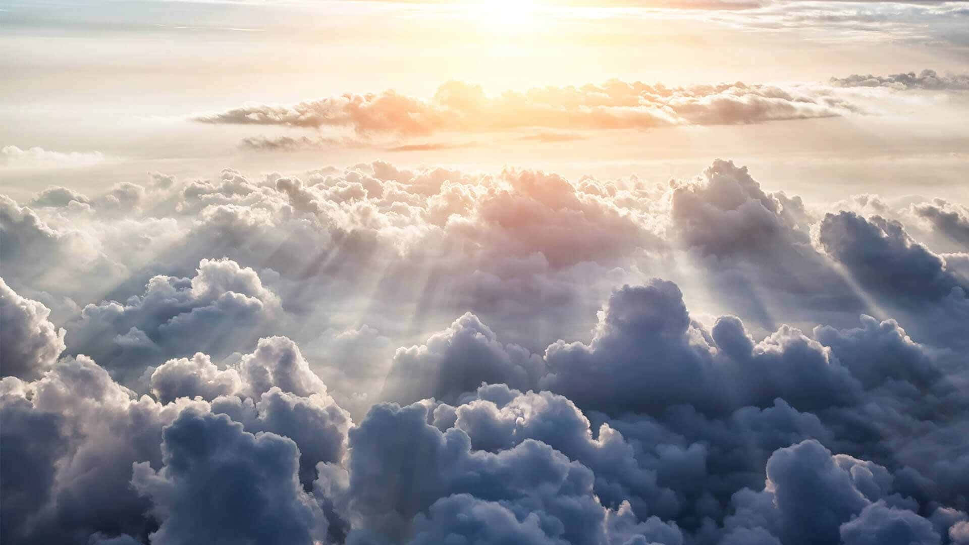 在寧靜的日出時分，陽光穿過蓬鬆的雲層照耀。