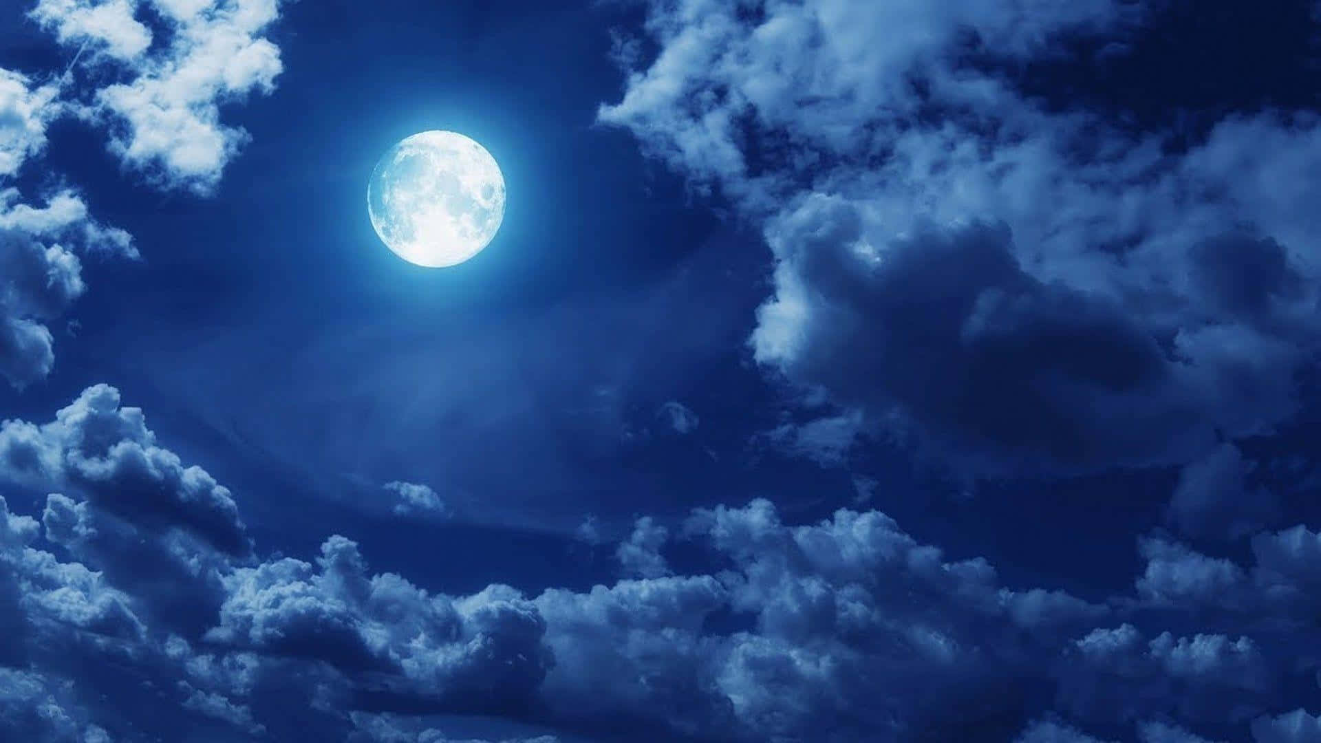 雲層後的滿月 壁紙 — 一輪明亮的滿月在深藍色夜空中，透過戲劇性的漩渦雲層發光。