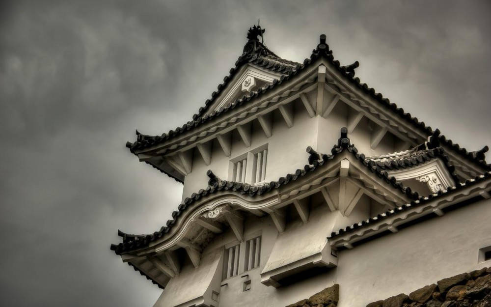 暴風雨天空下的歷史日本城堡塔樓。