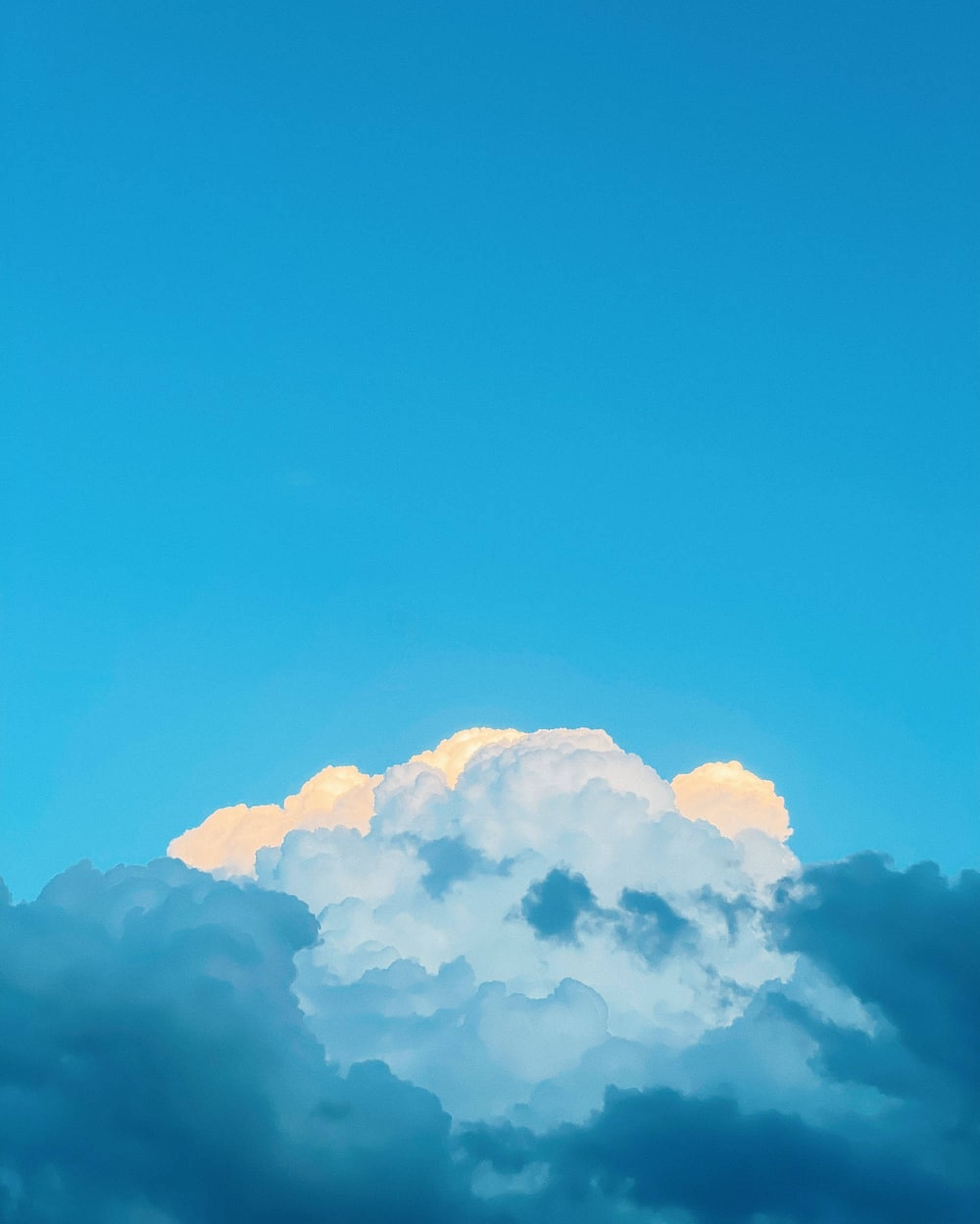 雲朵對比柔和天空背景 壁紙 — 戲劇性的雲層在深藍色天空的日落中閃耀著金色光芒。