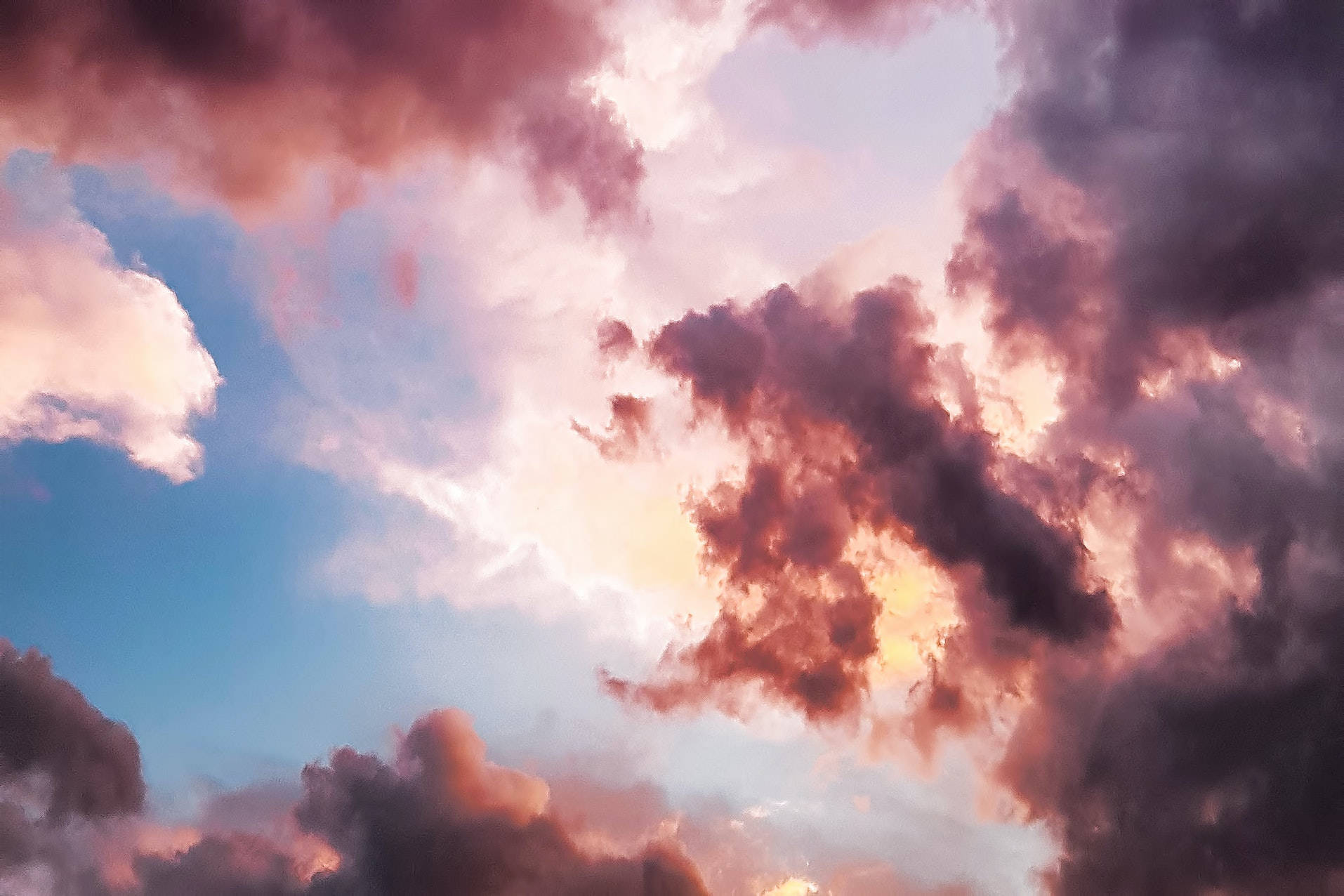 雲海 4K 高清筆記本電腦壁紙 壁紙 — 戲劇性的雲朵在日落時分，在柔和的藍天映襯下泛起粉紅與金色。