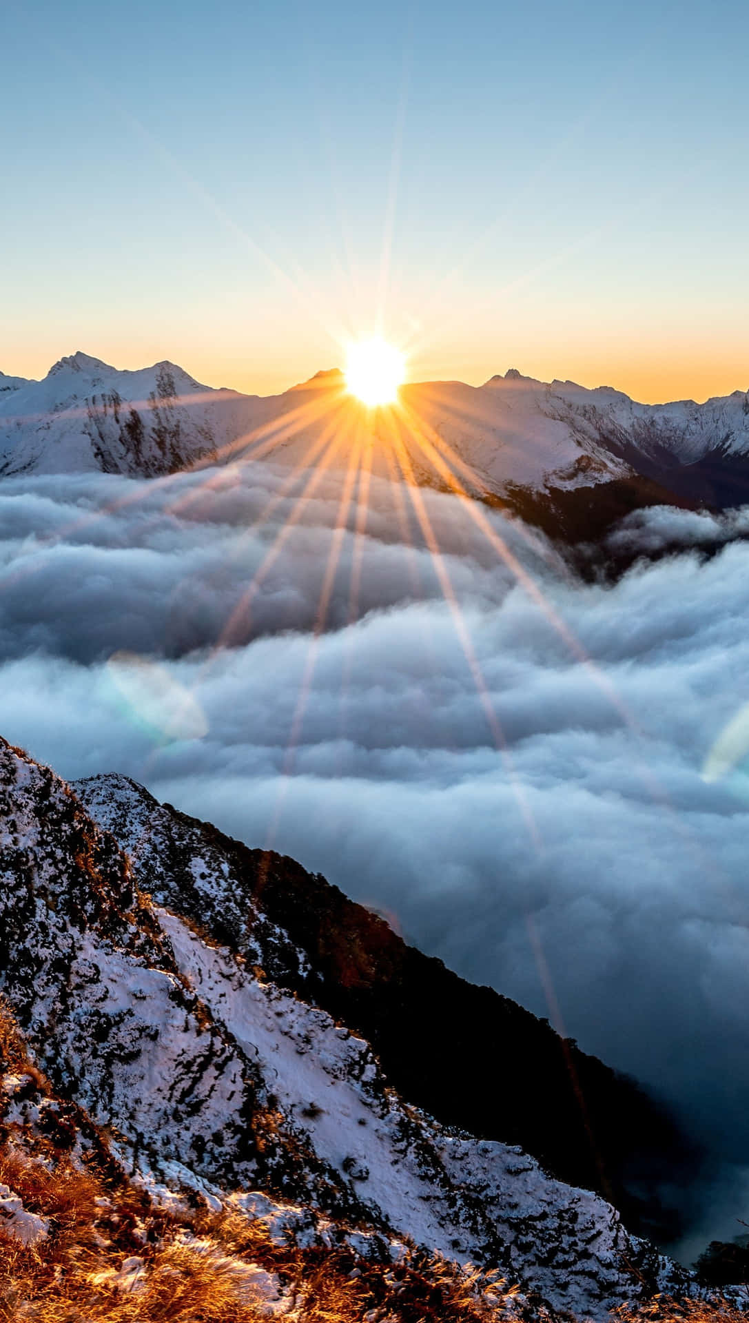 日出於雲海之上白雪覆蓋的山巒。