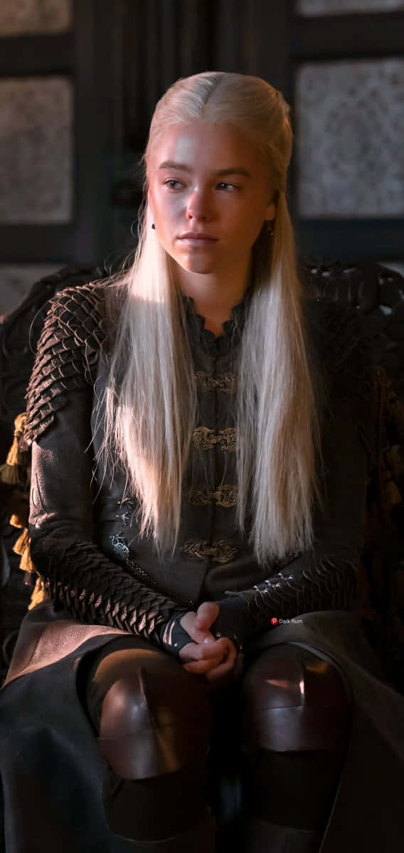 一位金髮女性身穿深色盔甲坐在王座上，陽光灑在她的頭髮上。
