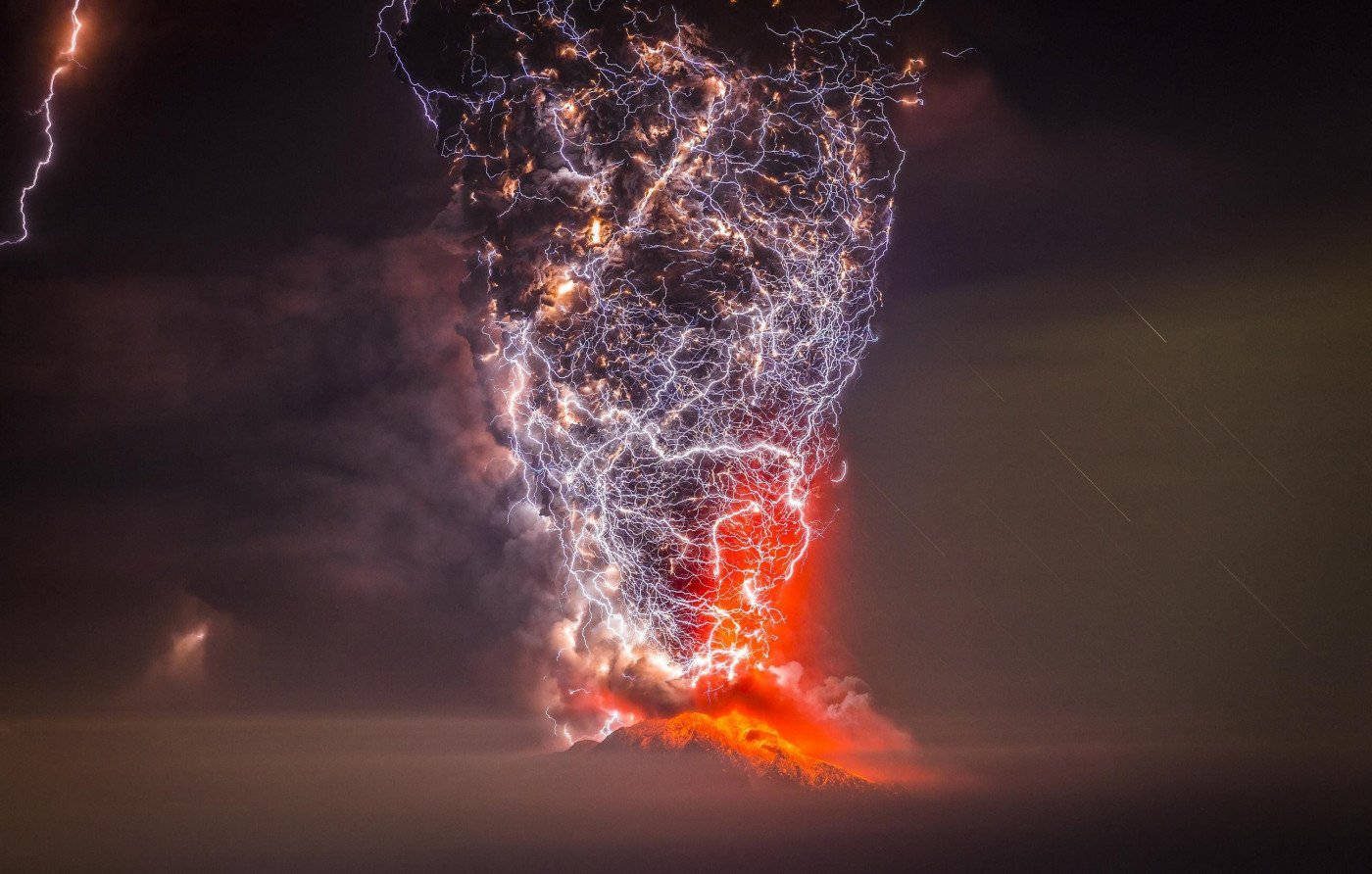 火山在夜間風暴中伴隨閃電噴發。