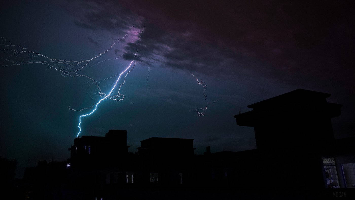 閃電擊中夜晚黑暗的城市屋頂。