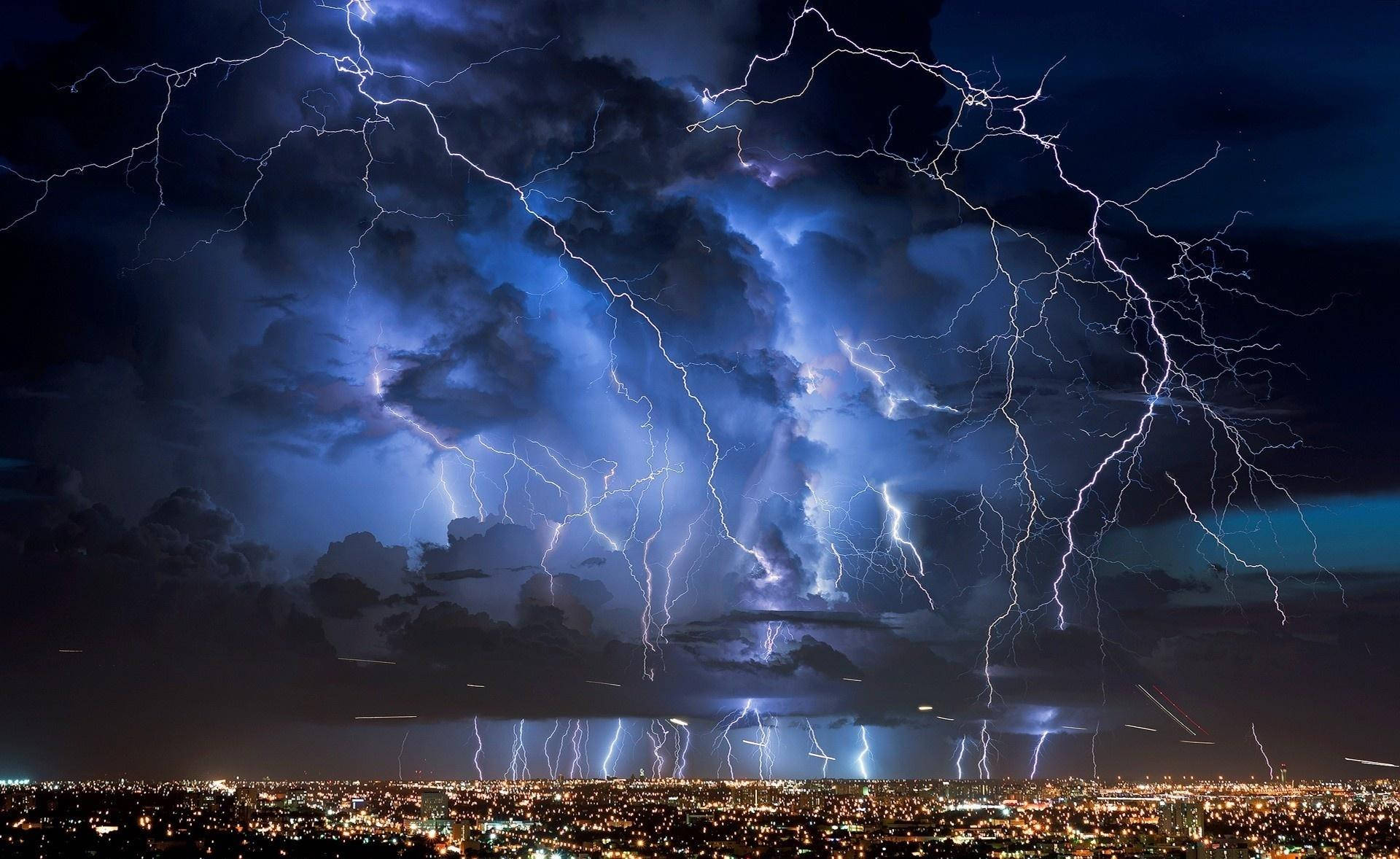 在充滿明亮閃電和烏雲的天空下，一座城市被照亮。