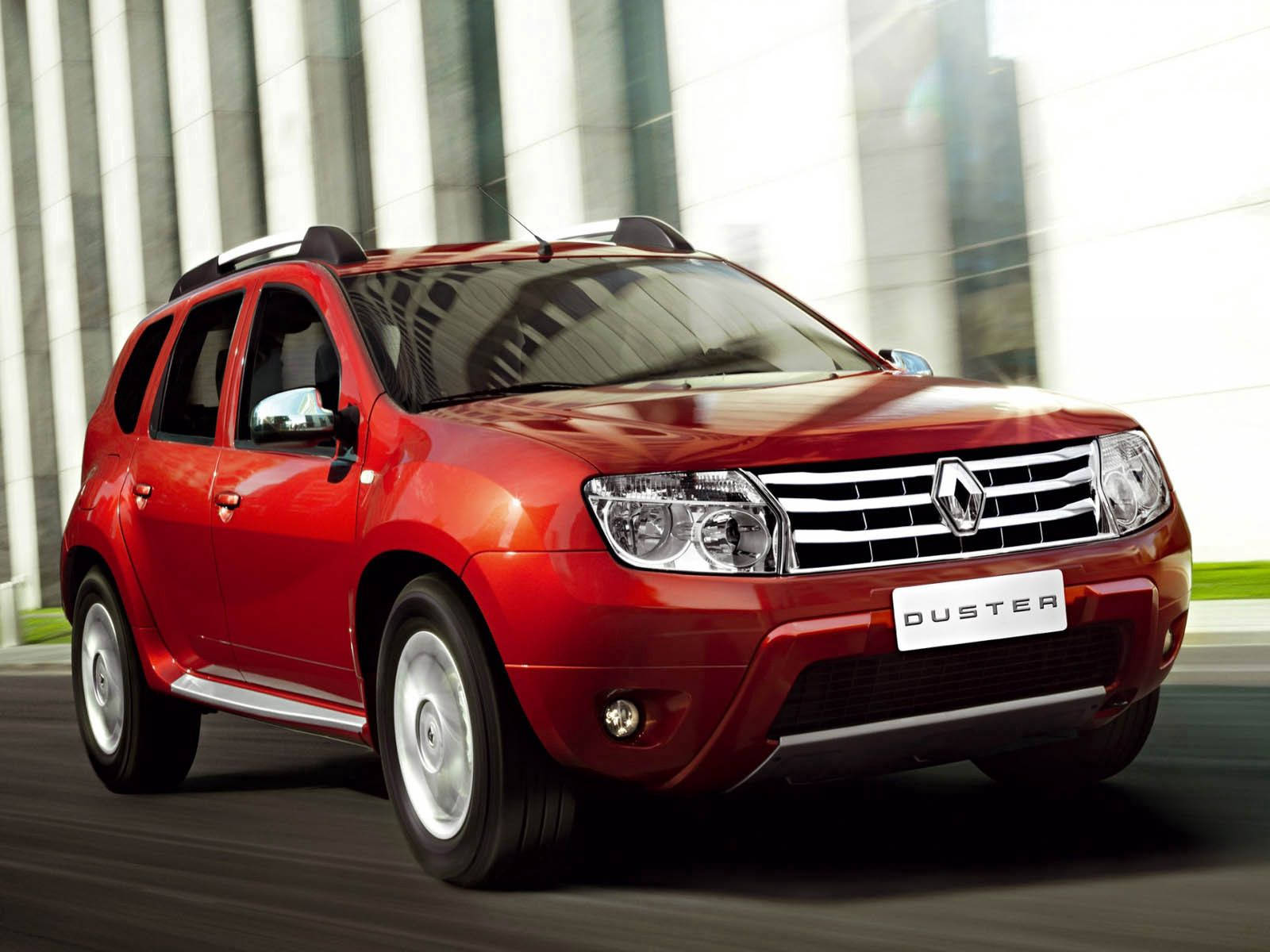 紅色雷諾 Duster SUV 駛過現代玻璃建築。