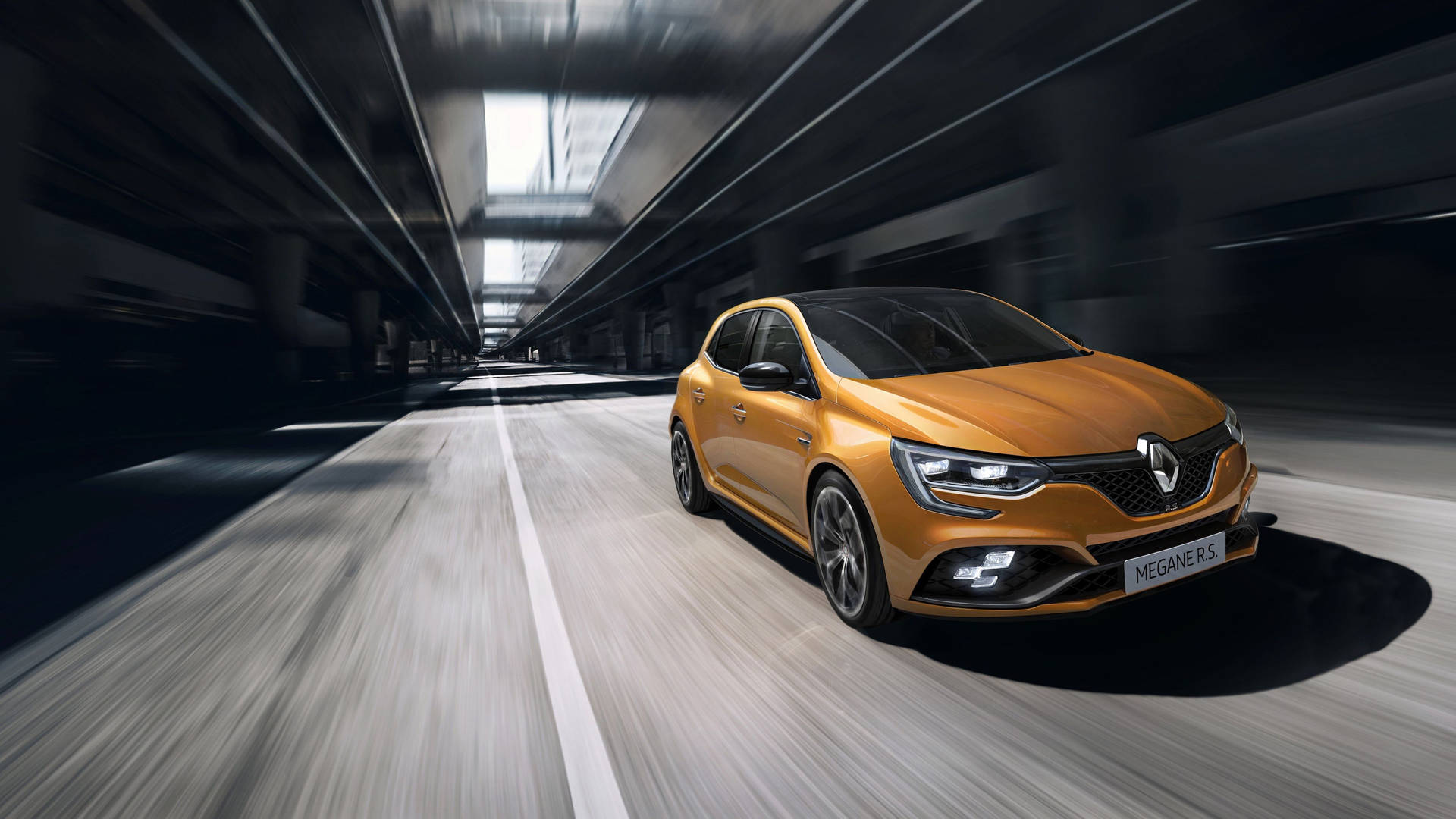 橙色雷諾 Mégane R.S. 在黑暗隧道中疾馳，帶有動態模糊。