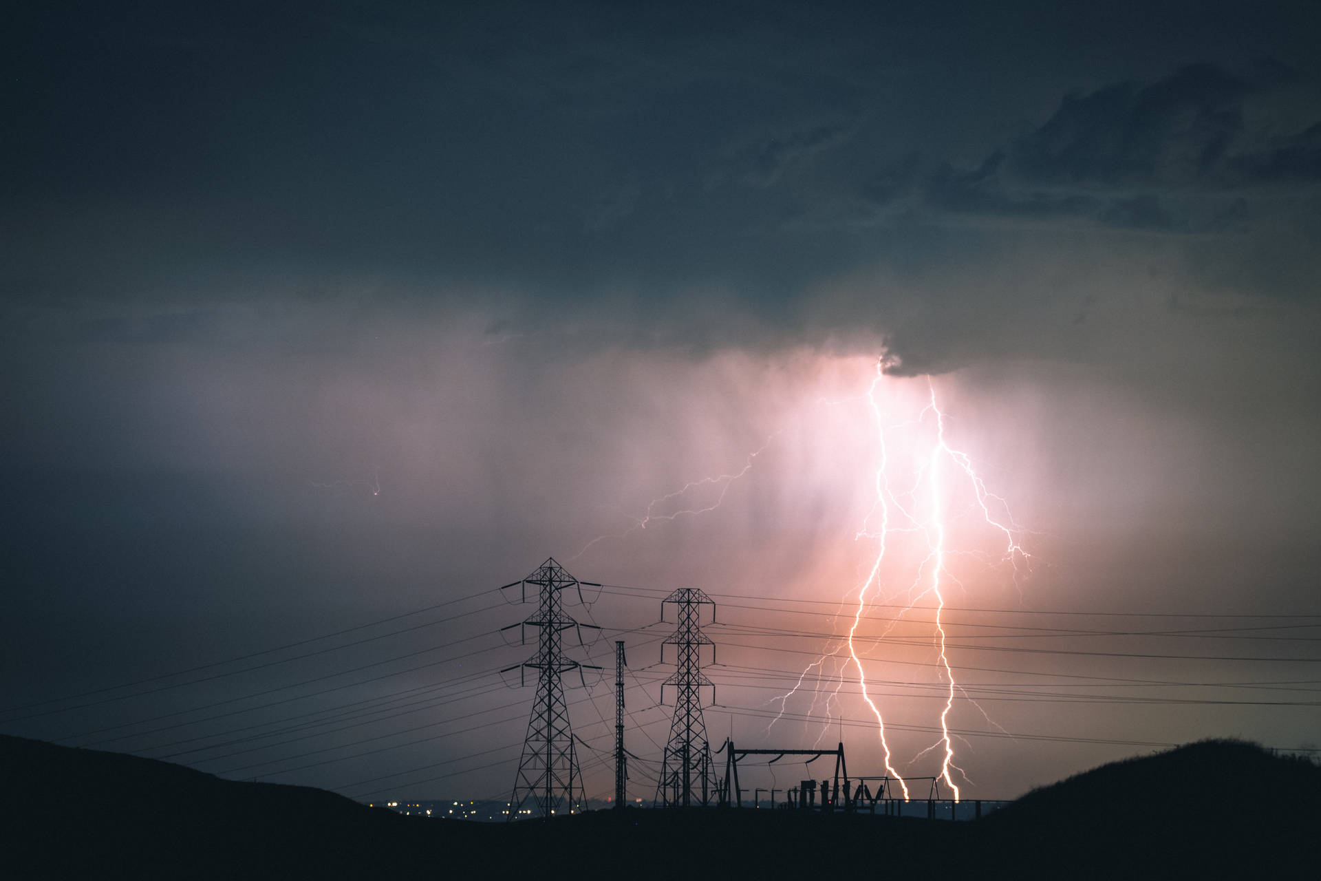 閃電照亮了黑暗暴風雨天空下的電線。