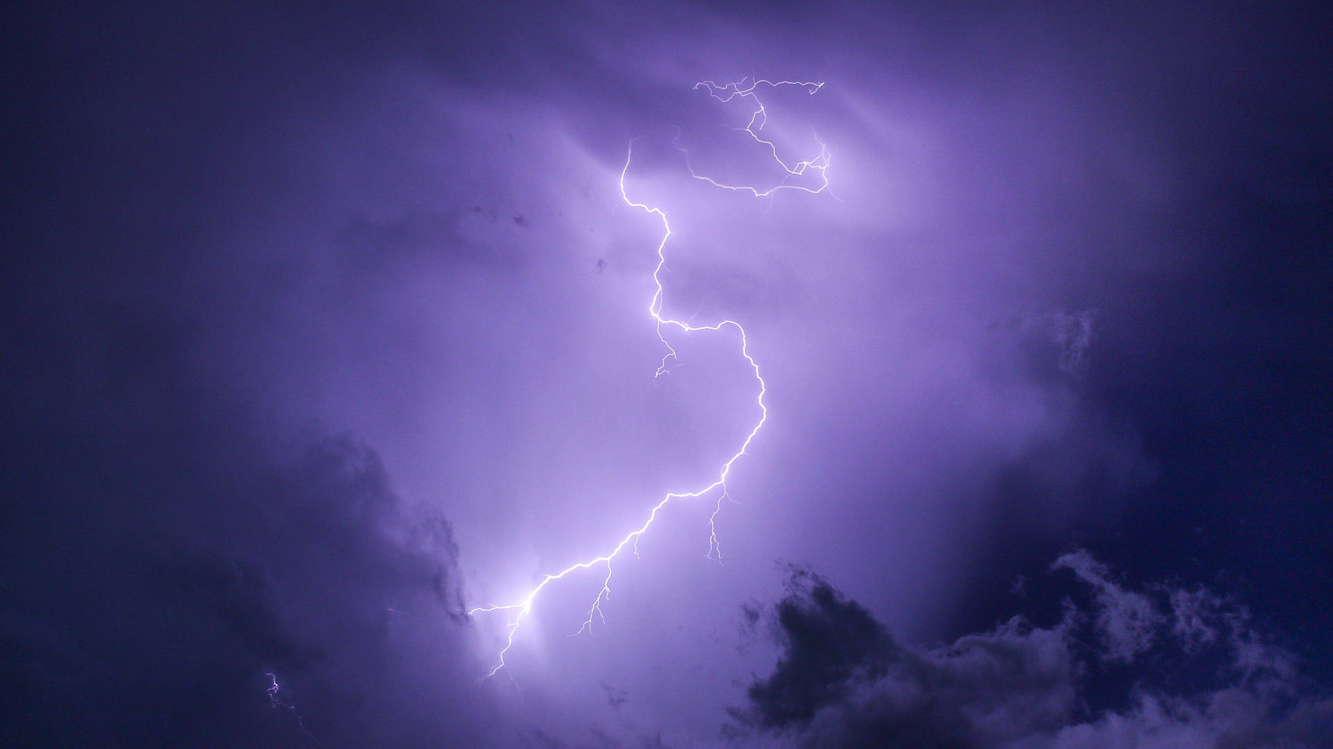 強烈的閃電照亮了暴風雨的紫色夜空。