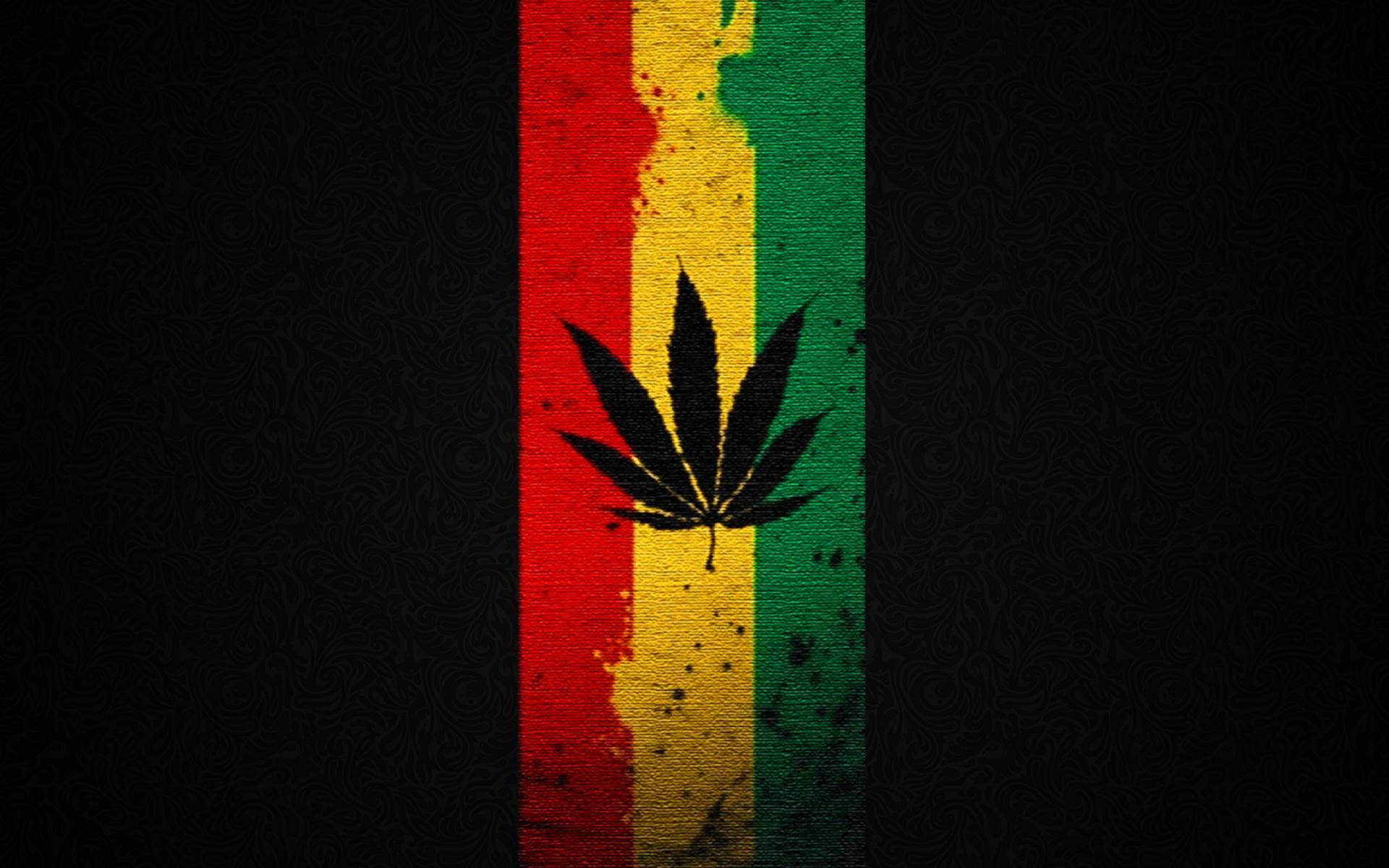 雷鬼拉斯特法里旗幟 壁紙 — 一個大膽的大麻葉剪影，居中於一條磨損的垂直條紋（紅、黃、綠），背景為深色紋理。