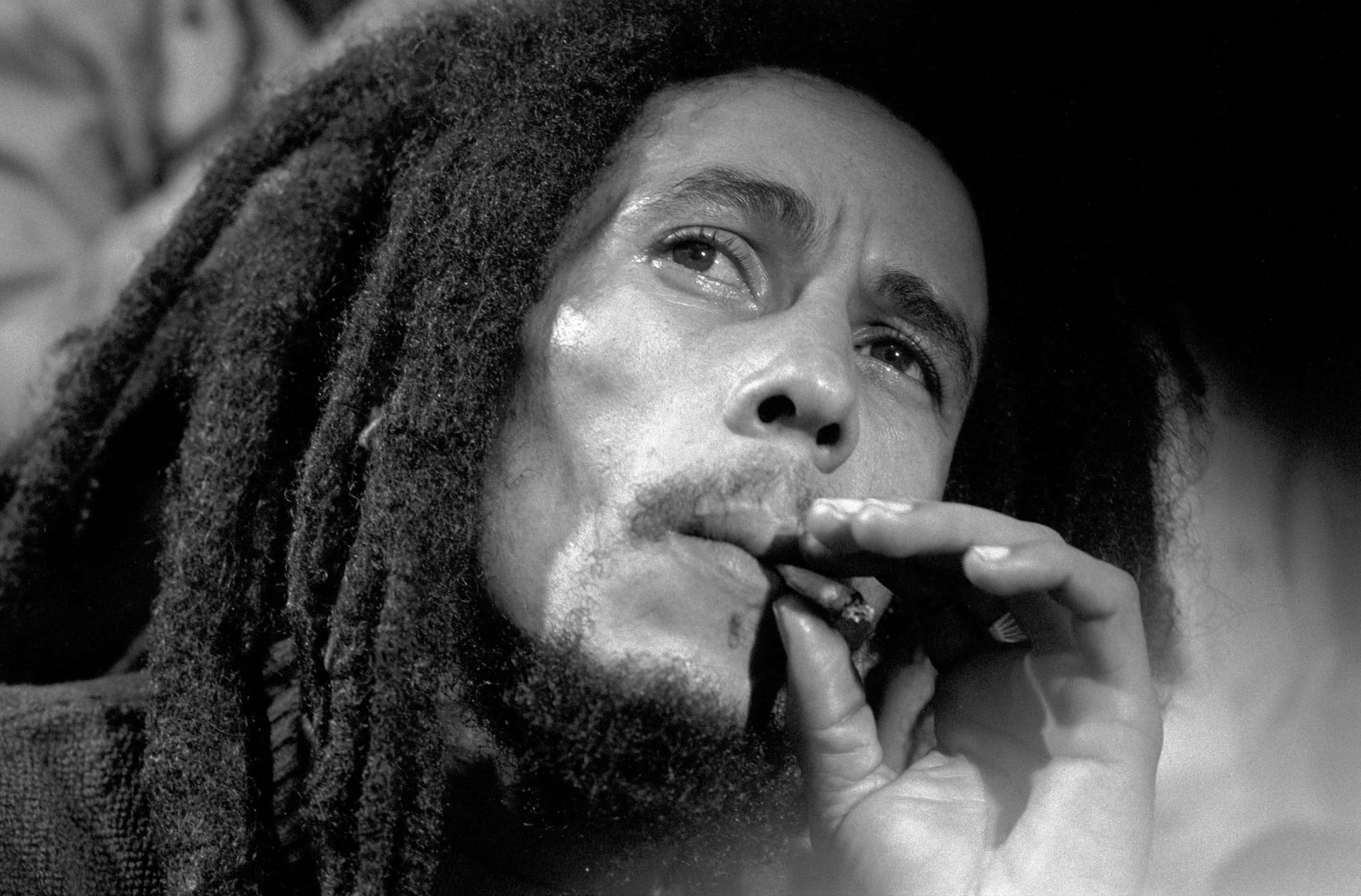 雷鬼時代最具代表性的專業歌手——鮑勃·馬利 壁紙 — Bob Marley 吸煙的黑白特寫，眼神向上凝視，帶有紋理的辮子。