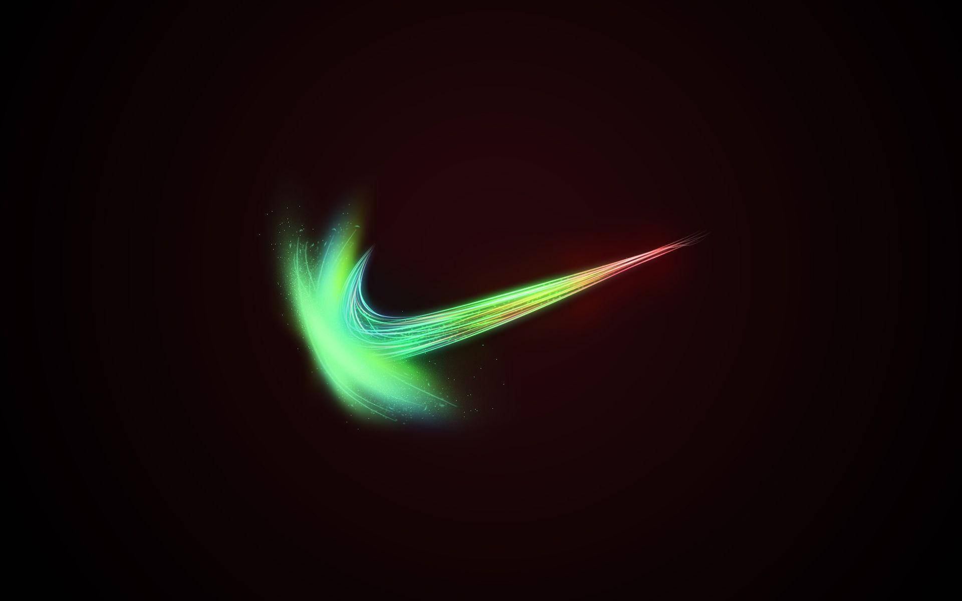 雷鬼風酷炫耐克標誌 壁紙 — 發光的霓虹Nike勾號在深色背景上劃過，帶有鮮豔的綠色、黃色和紅色色調。