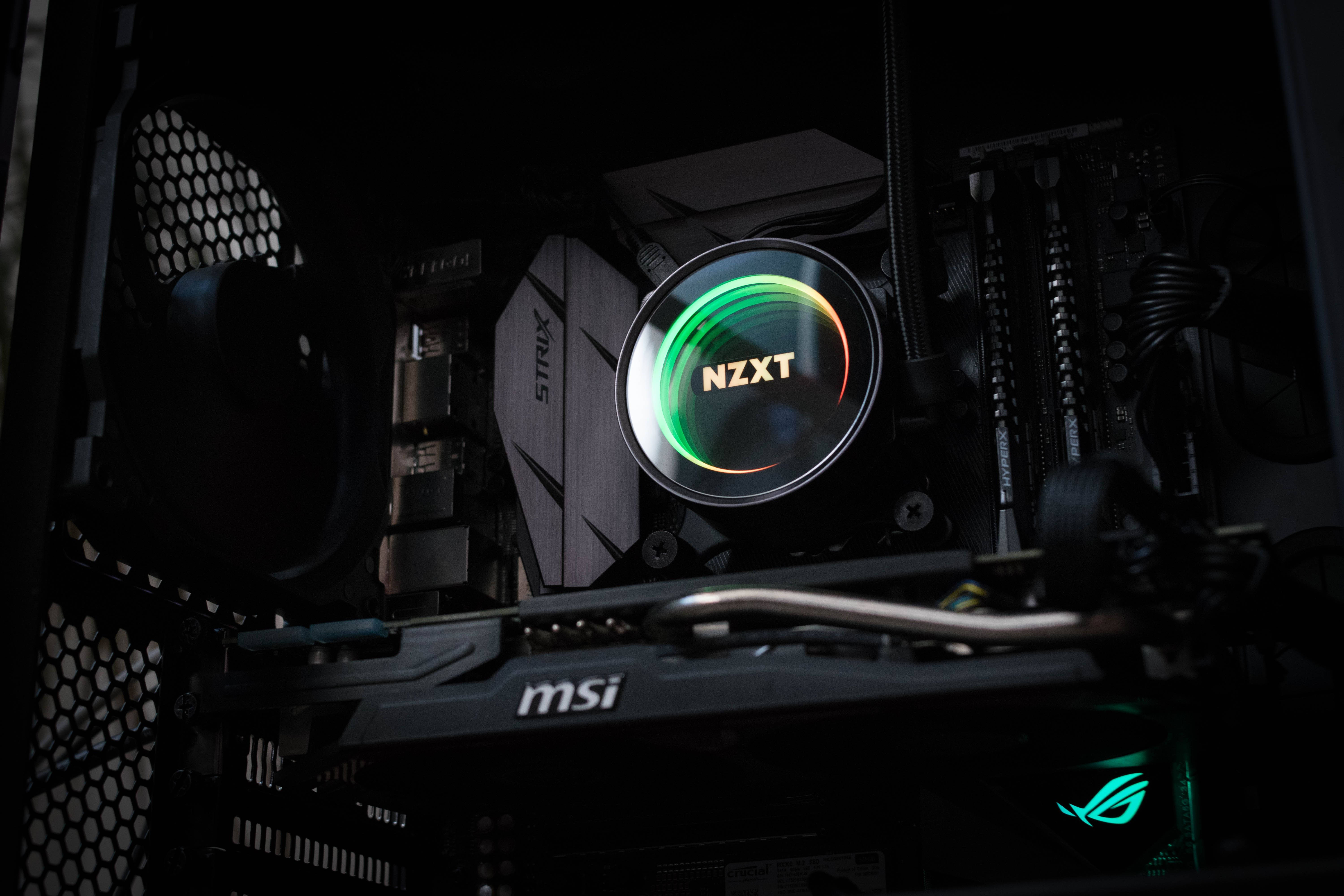 電子中央處理器 壁紙 — 暗色電腦機箱內發光嘅NZXT CPU散熱器特寫，配備MSI底板同RGB燈光點綴。