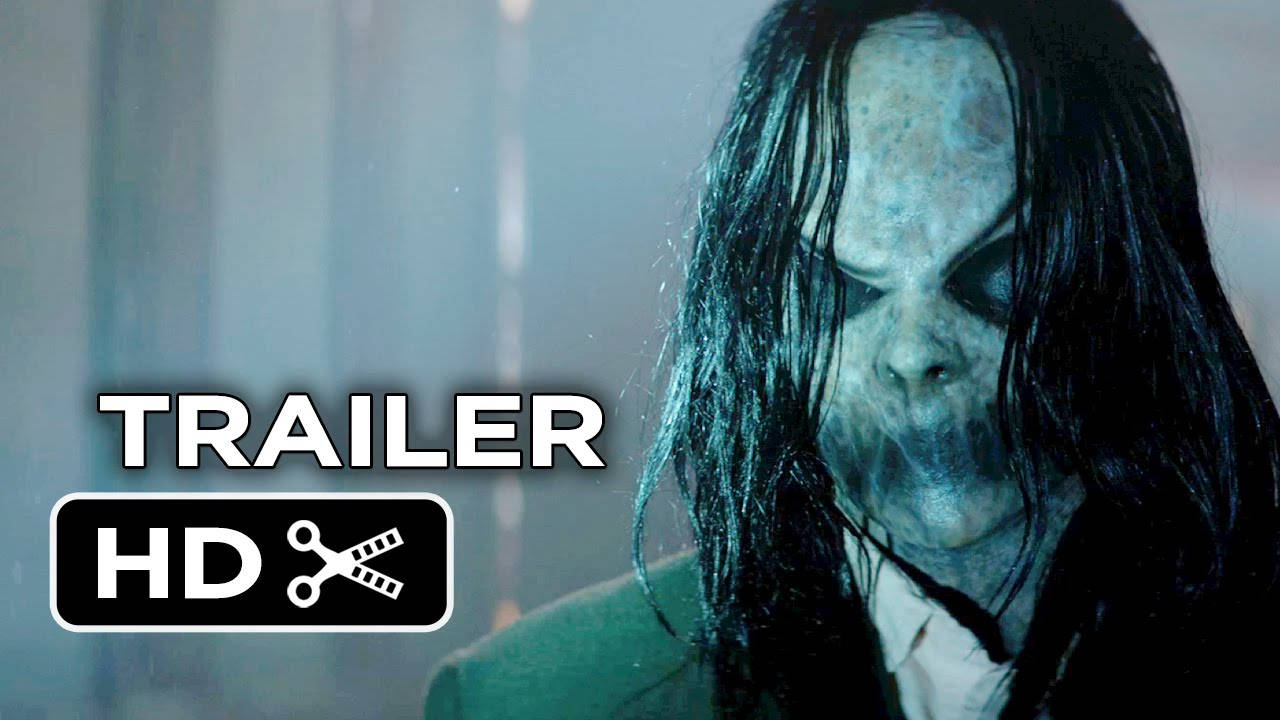 電影《Sinister》預告片截圖 壁紙 — 一個蒼白的鬼魂般的身影，長著深色長髮和閉著的眼睛，在昏暗的房間裡莊嚴地凝視著。