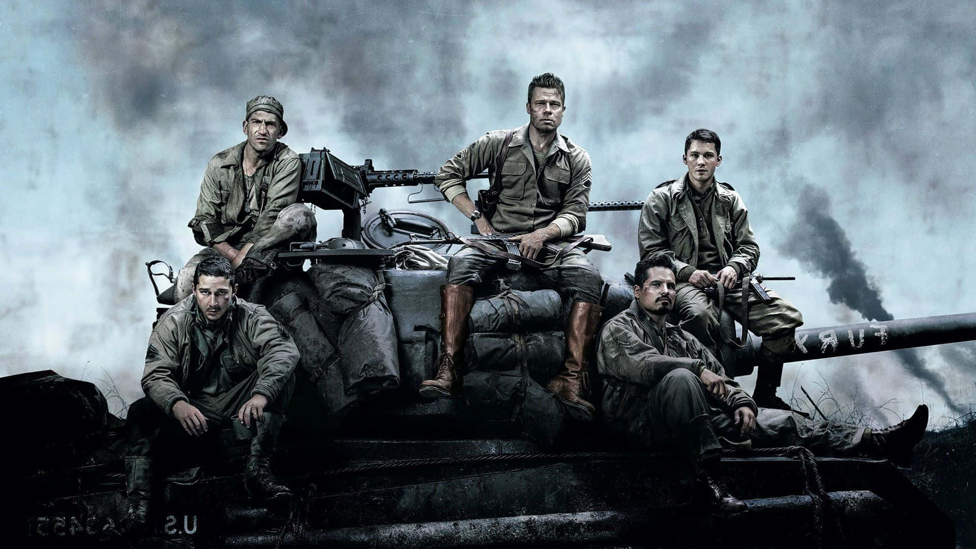 五名身穿軍裝的士兵坐在煙霧瀰漫的戰區中的一輛坦克上。