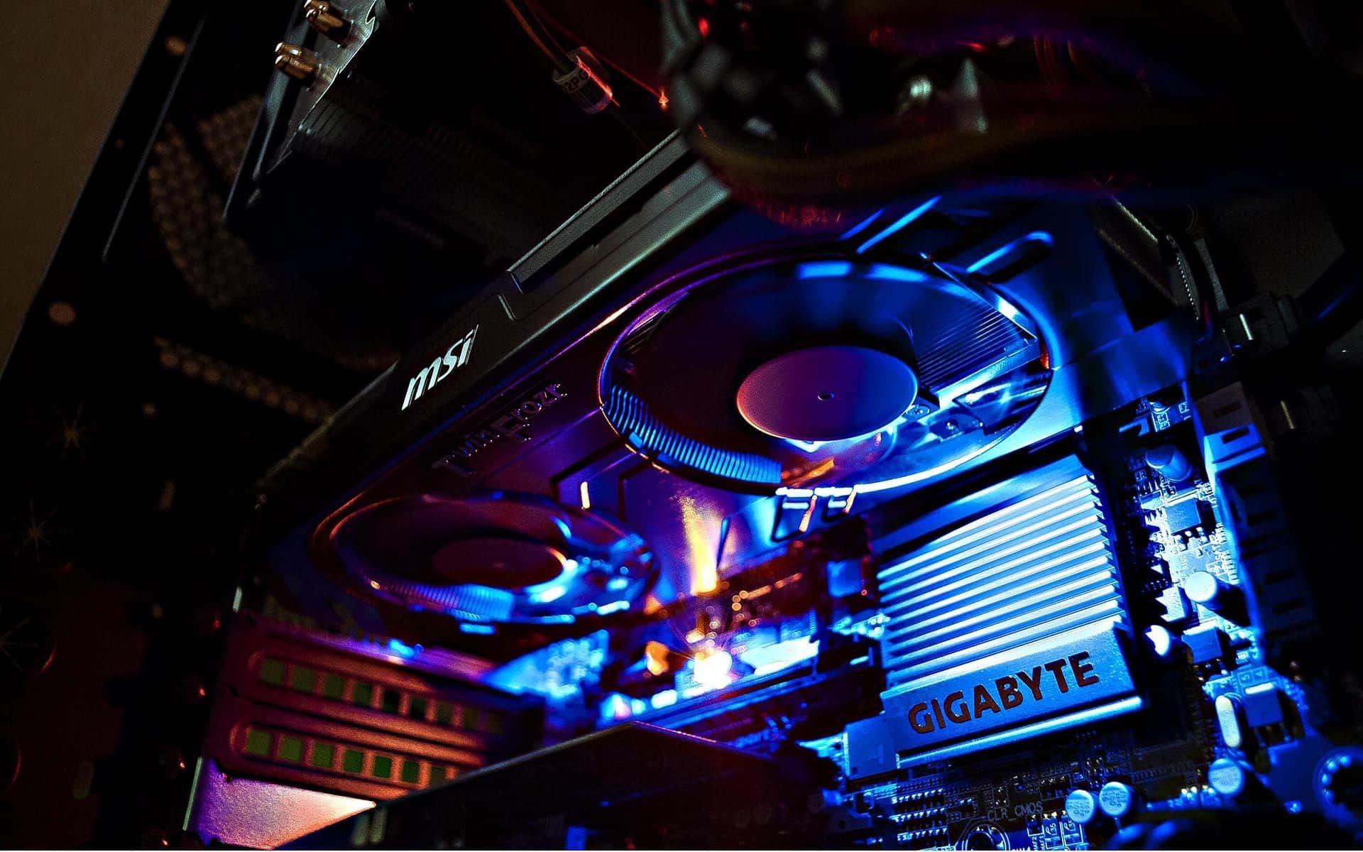 4K Graphics Cards 桌布 壁紙 — 電腦機箱內部發出藍色和紫色光芒的顯示卡和主機板特寫。