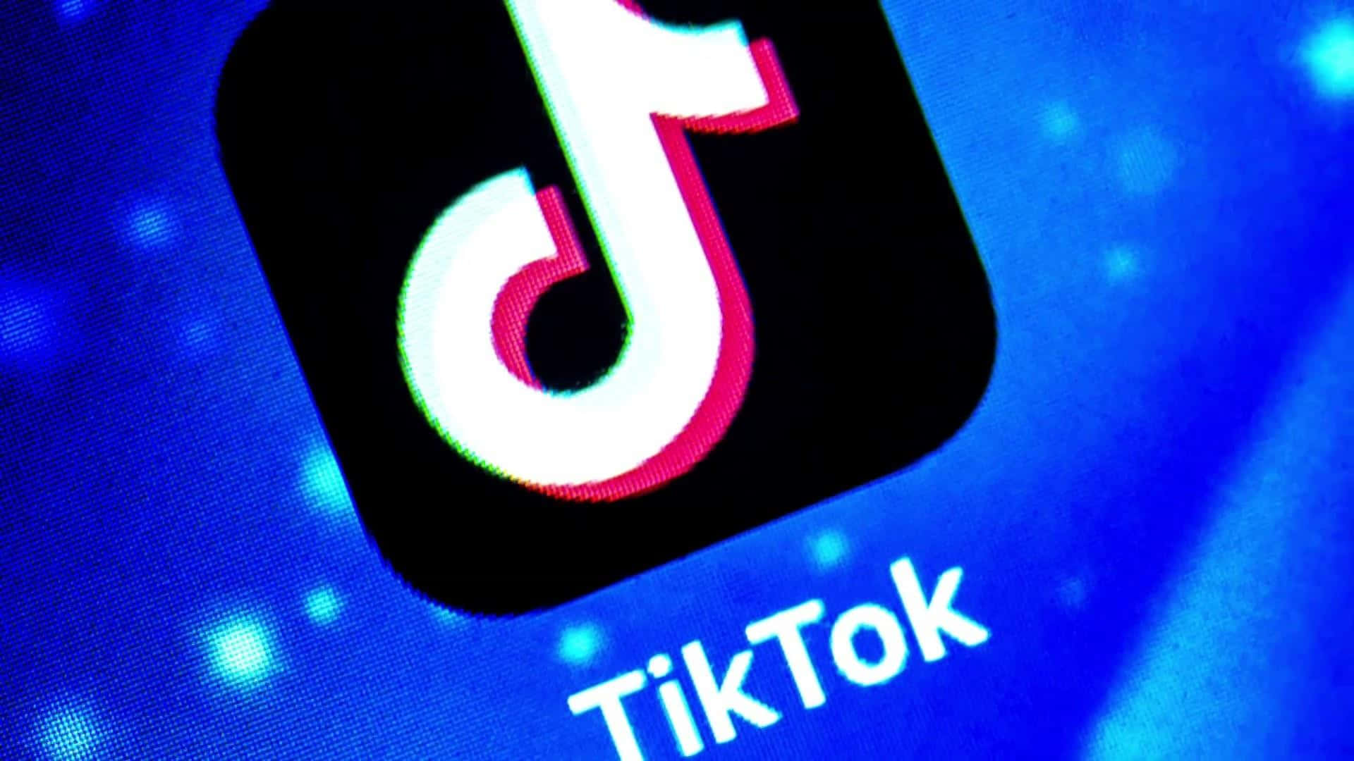 TikTok應用程式圖標在帶有像素紋理的藍色數碼屏幕上發光。