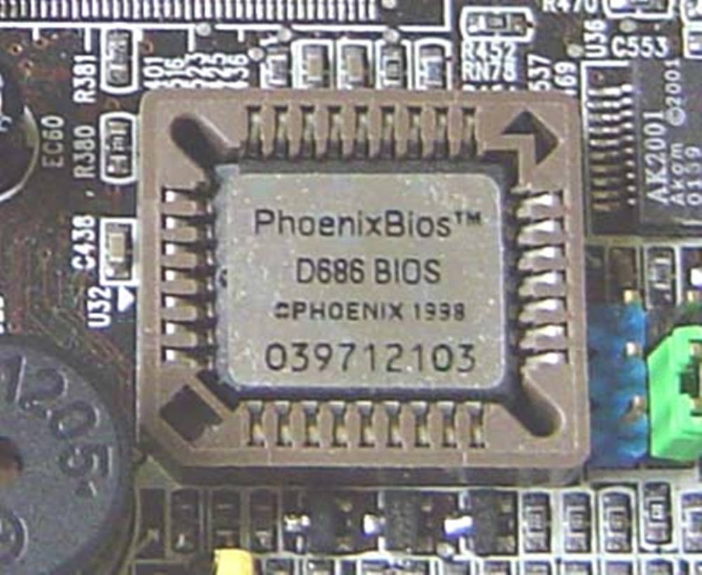 Phoenix BIOS 1998 壁紙 — 電路板上Phoenix BIOS晶片的特寫，可見焊接元件和印刷標籤。