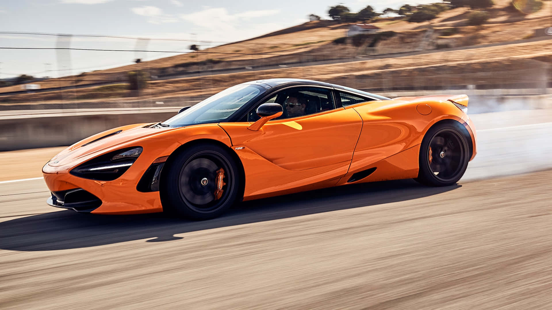 橙色McLaren 720S在日落時分的賽道上疾馳