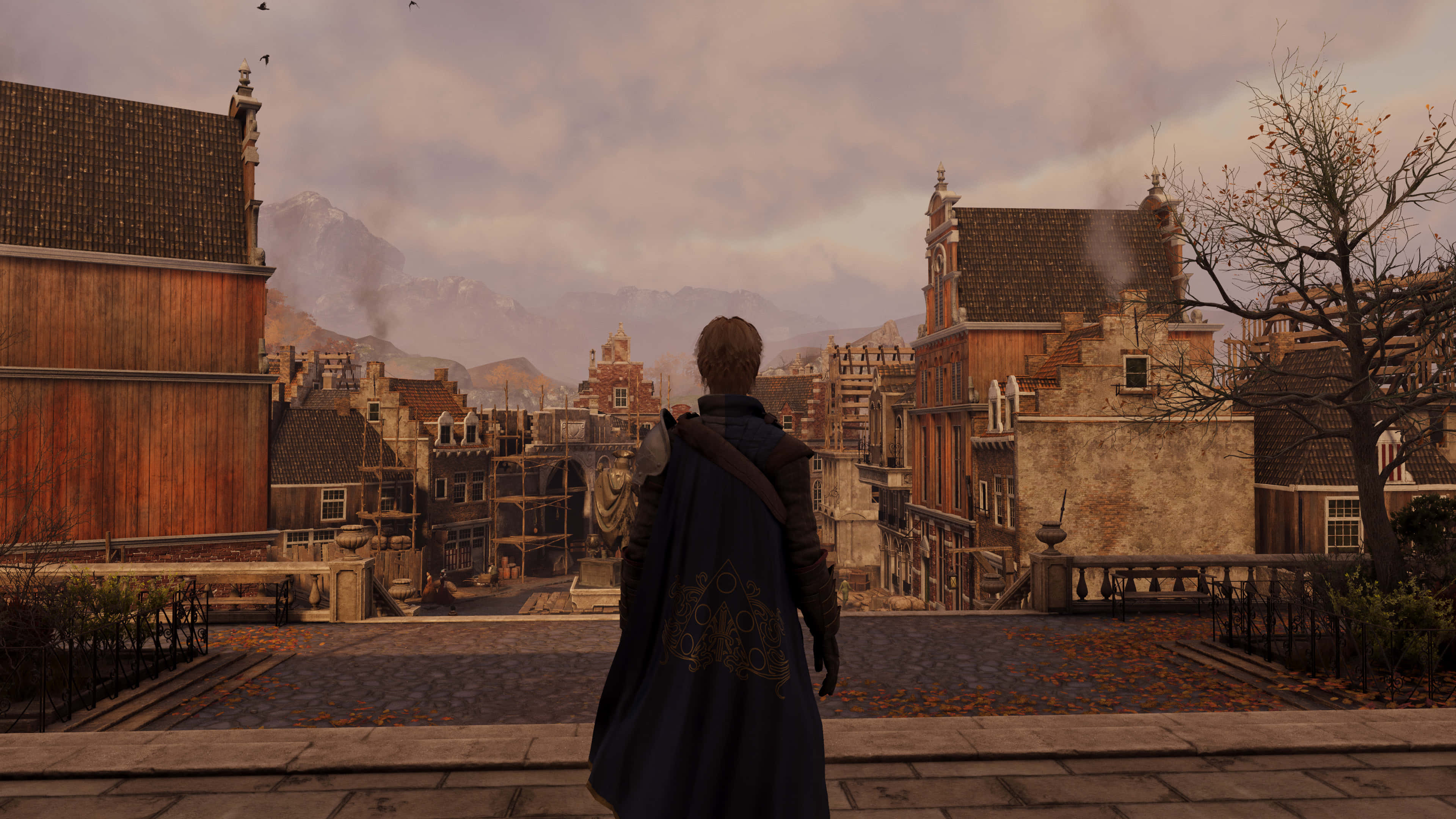 震撼高畫質《GreedFall》背景 壁紙 — 一個孤獨的身影穿著深色斗篷站在屋頂上，俯瞰著一個歷史悠久的歐洲小鎮，有秋葉和遠山，天空多雲。