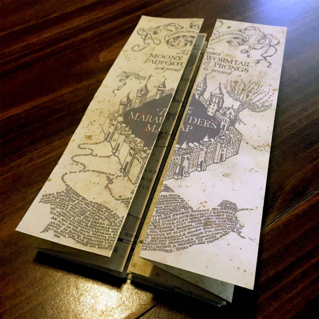 兩個哈利波特劫盜地圖書籤放在木質表面上。